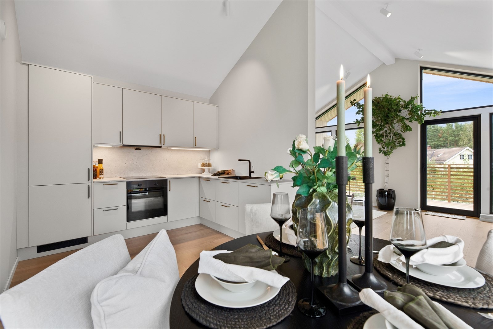 Kjøkkenets innredning har lyse glatte fronter, laminat benkeplate med nedfelt oppvaskkum av kompositt, ventilator og belysning under overskap. Galleribilde