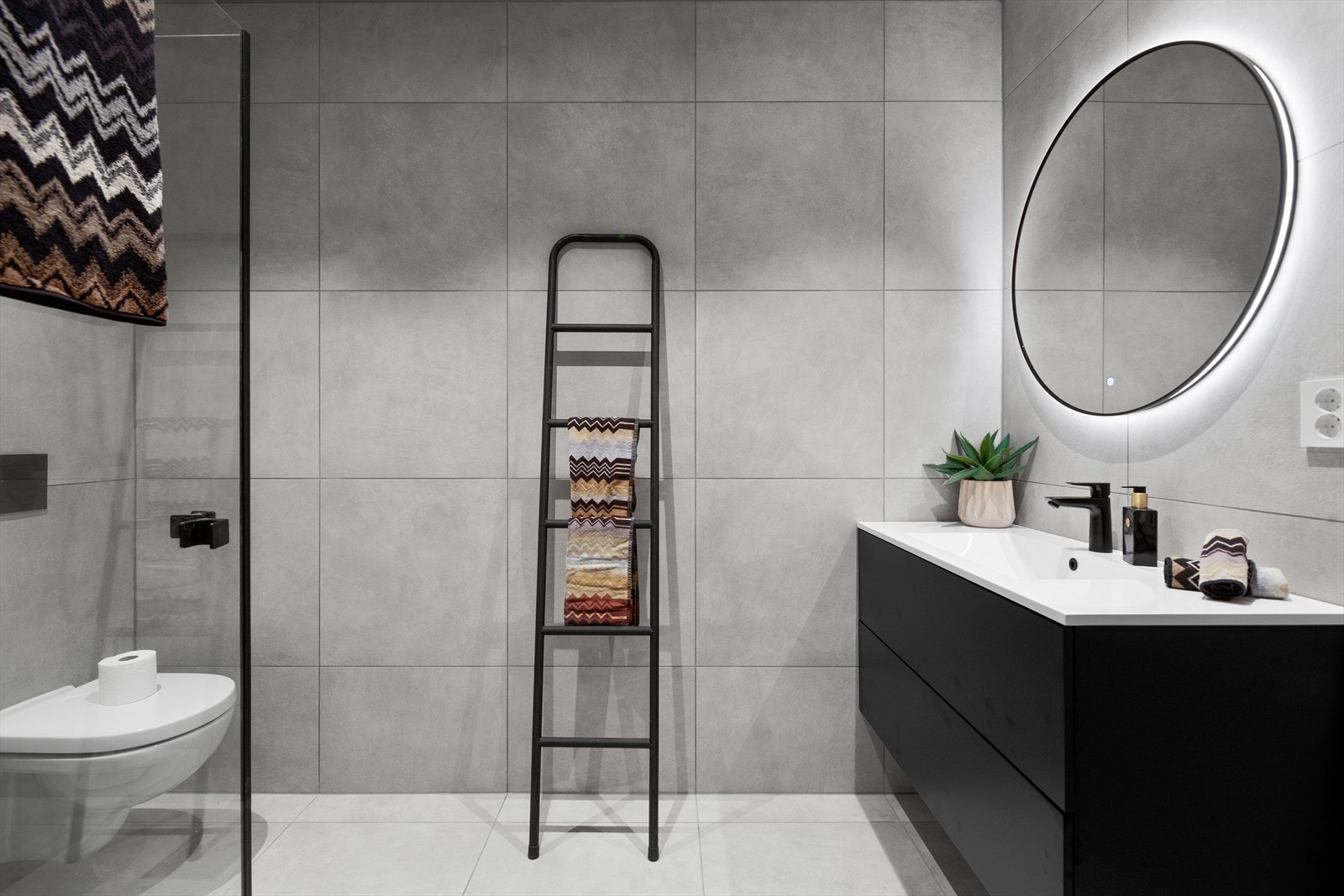 Badet i 1. etasje er innredet med en stilren baderomsinnredning med heldekkende servant, speil med lys, veggmontert toalett og dusjhjørne. Galleribilde