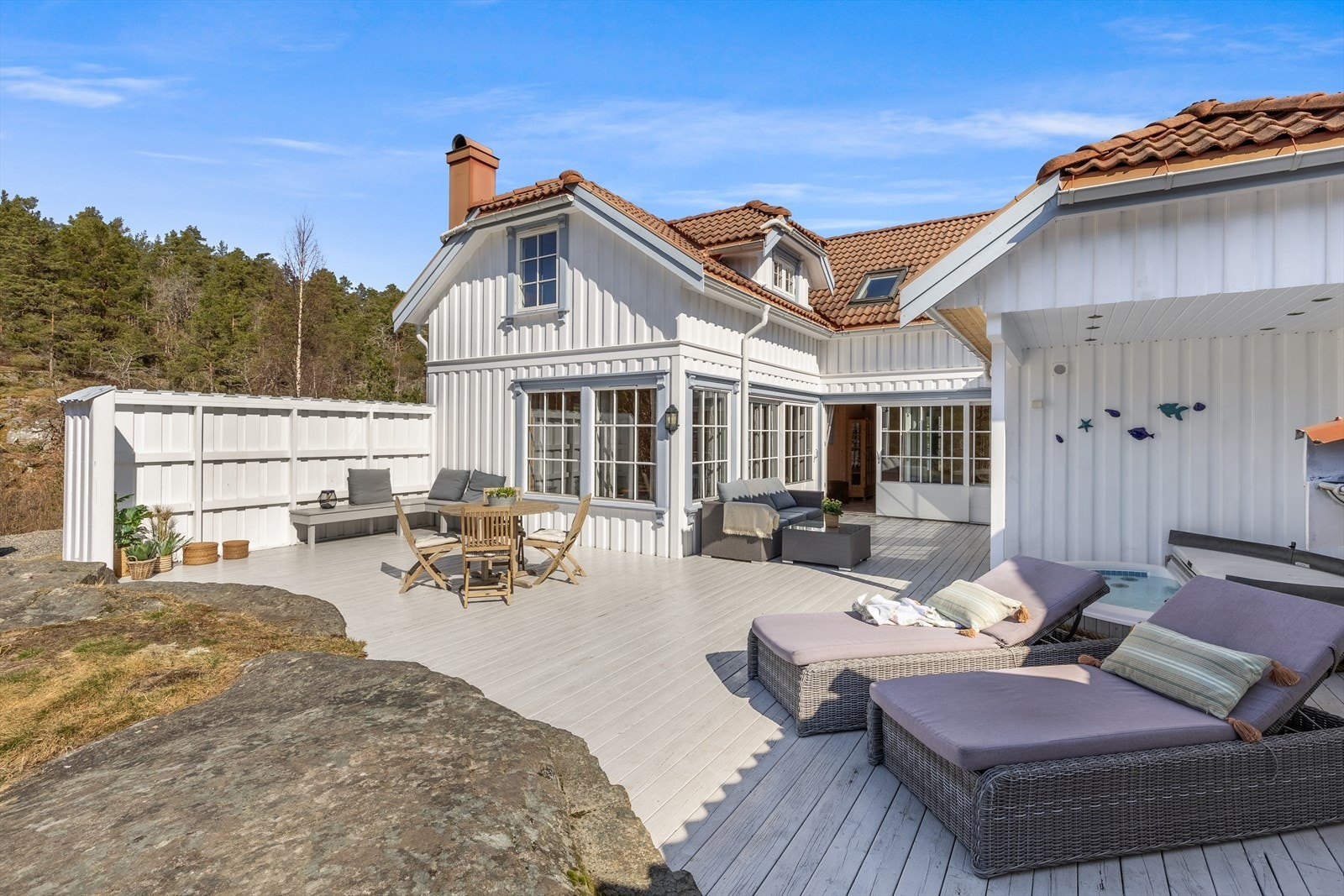 Romslige uteområder med overbygd tak, jaquzzi og flere soner for sittegrupper Galleribilde