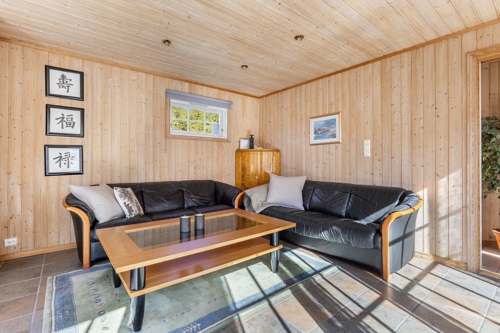 Lys og fin stue som får godt med naturlig lysinnlipp fra store vindusflater Galleribilde