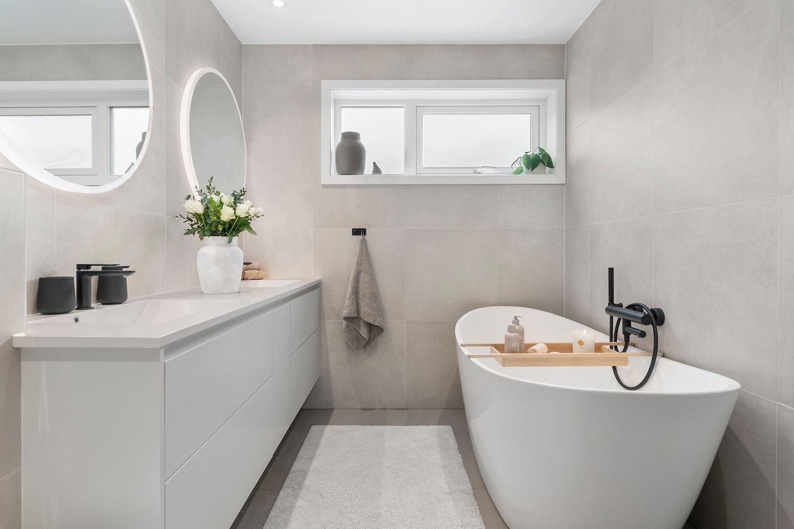 Badet i førsteetasjen har store, lyse fliser og både badekar og dusjhjørne med innfellbare vegger. Galleribilde