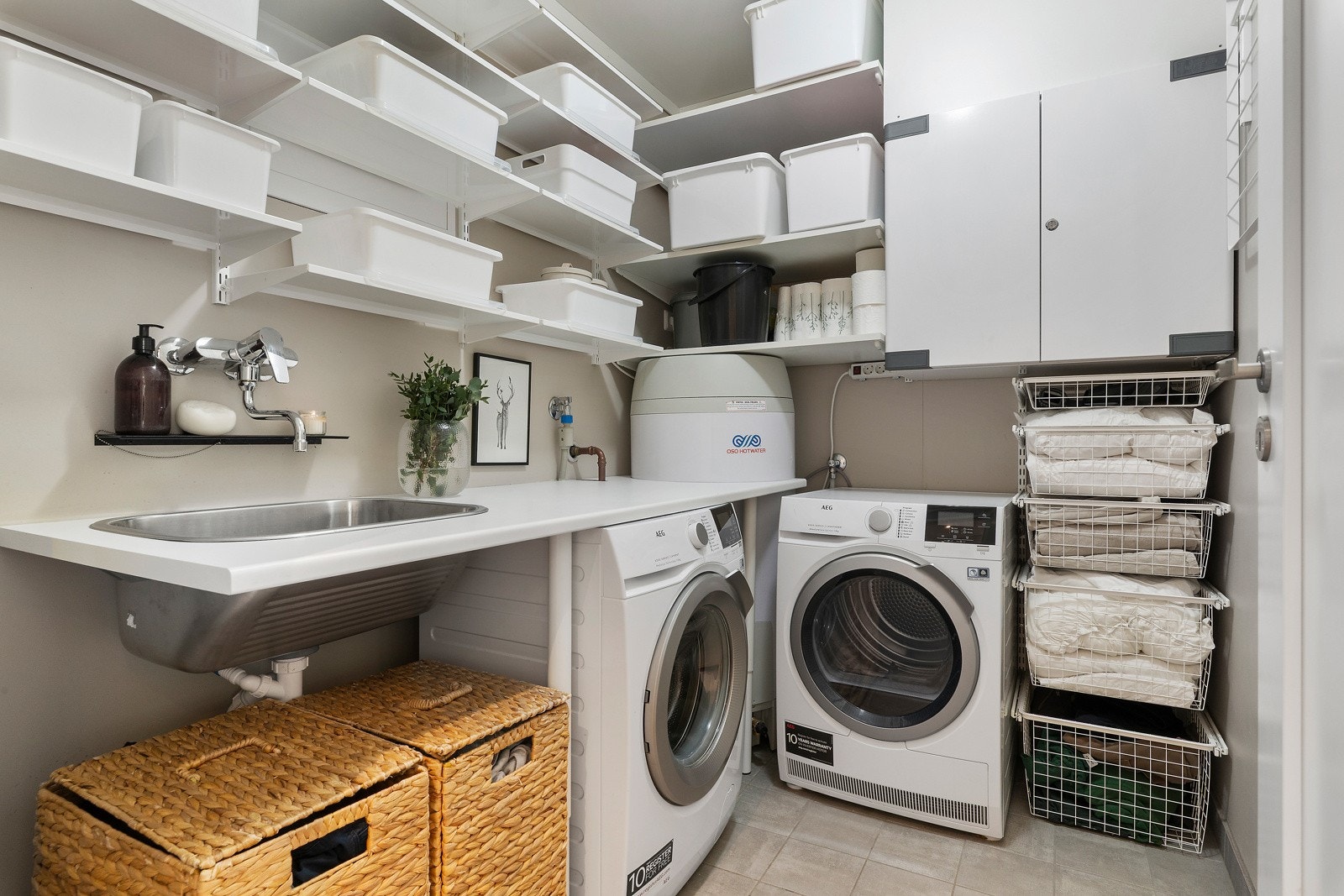 Eget vaskerom er deilig å kunne smykke seg med. Her er det godt med plass til oppbevaring samtidig som man får arbeidsbenk til klesbrettingen. Galleribilde