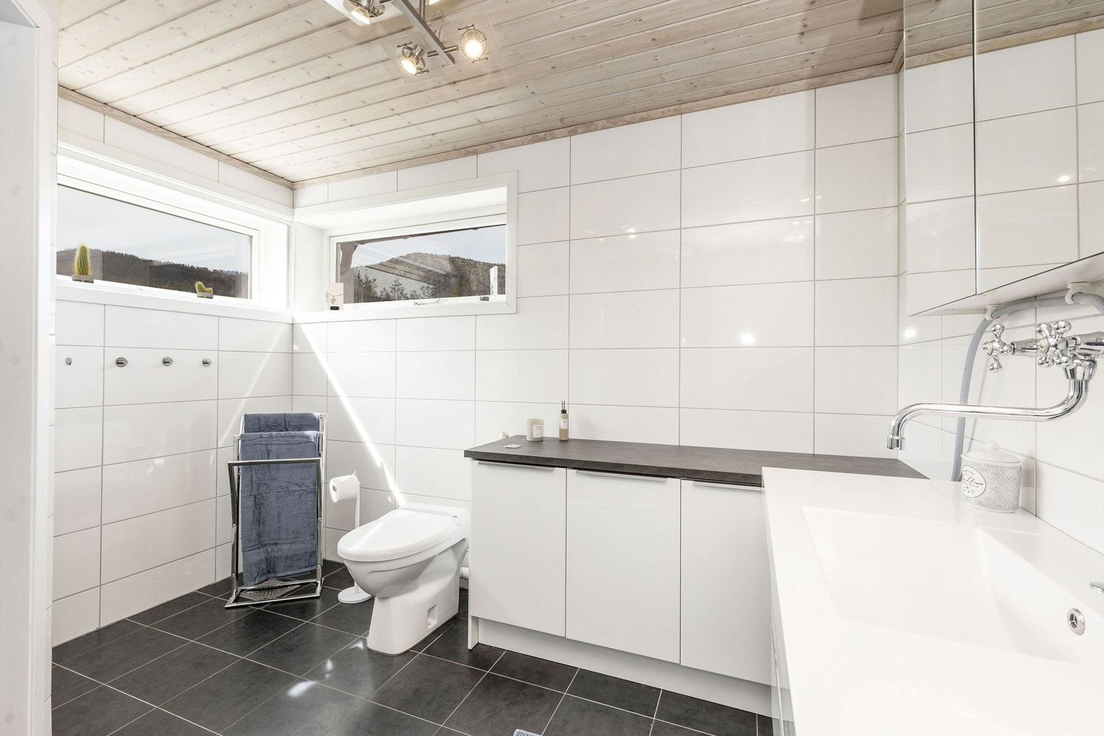 Pent flislagt bad med toalett, dusj og servantinnredning Galleribilde