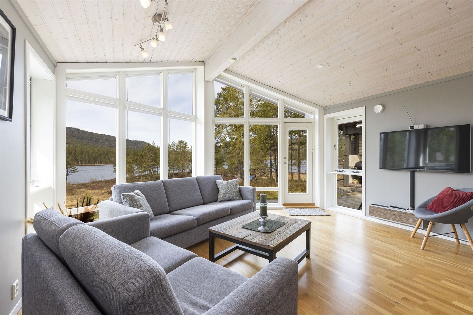 Luftig skråtak i stua kombinert med glassflatene sikrer mye lys og utsikt Galleribilde