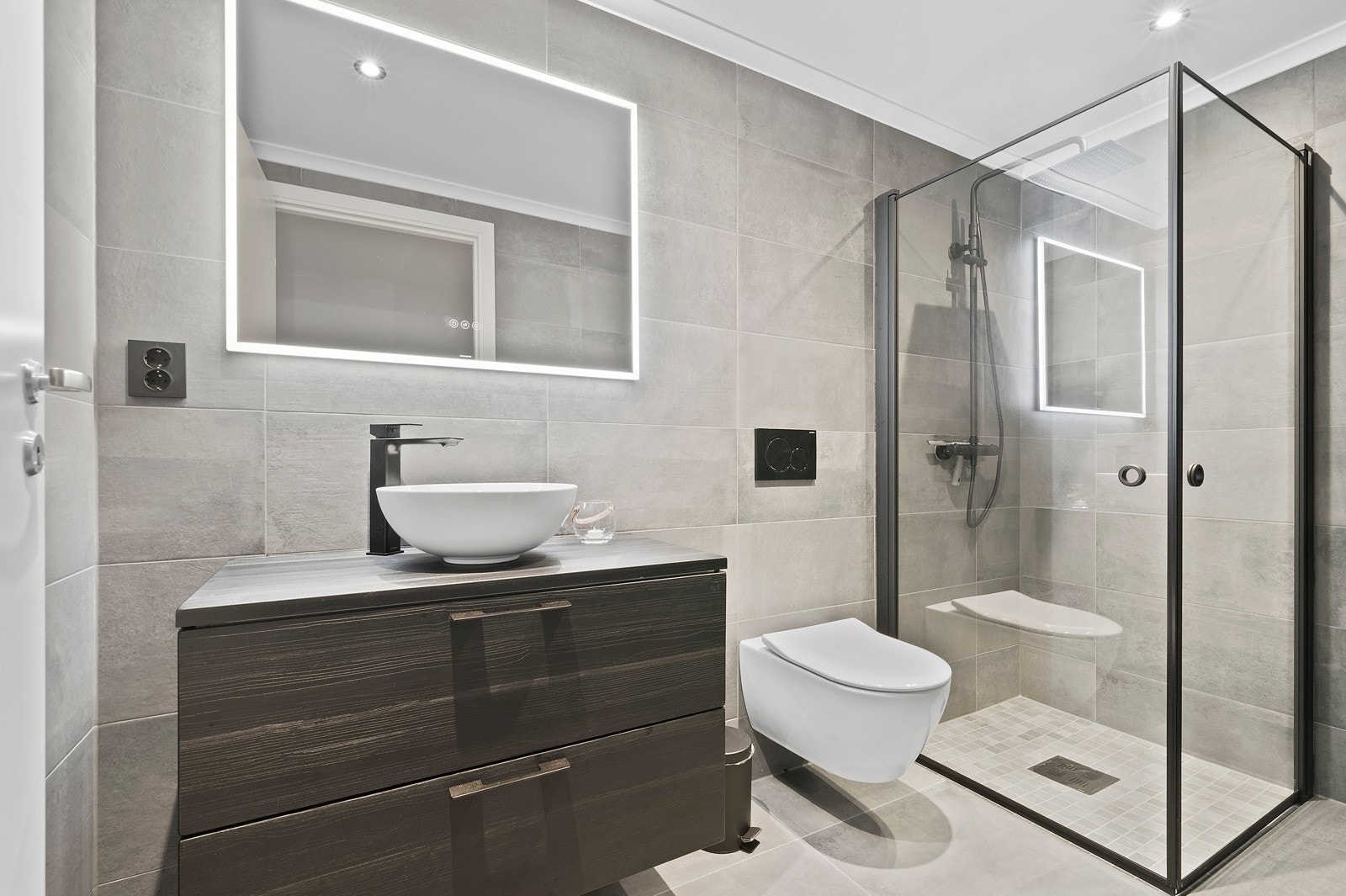 Badet er utstyrt med servantinnredning, vegghengt toalett og dusjhjørne Galleribilde