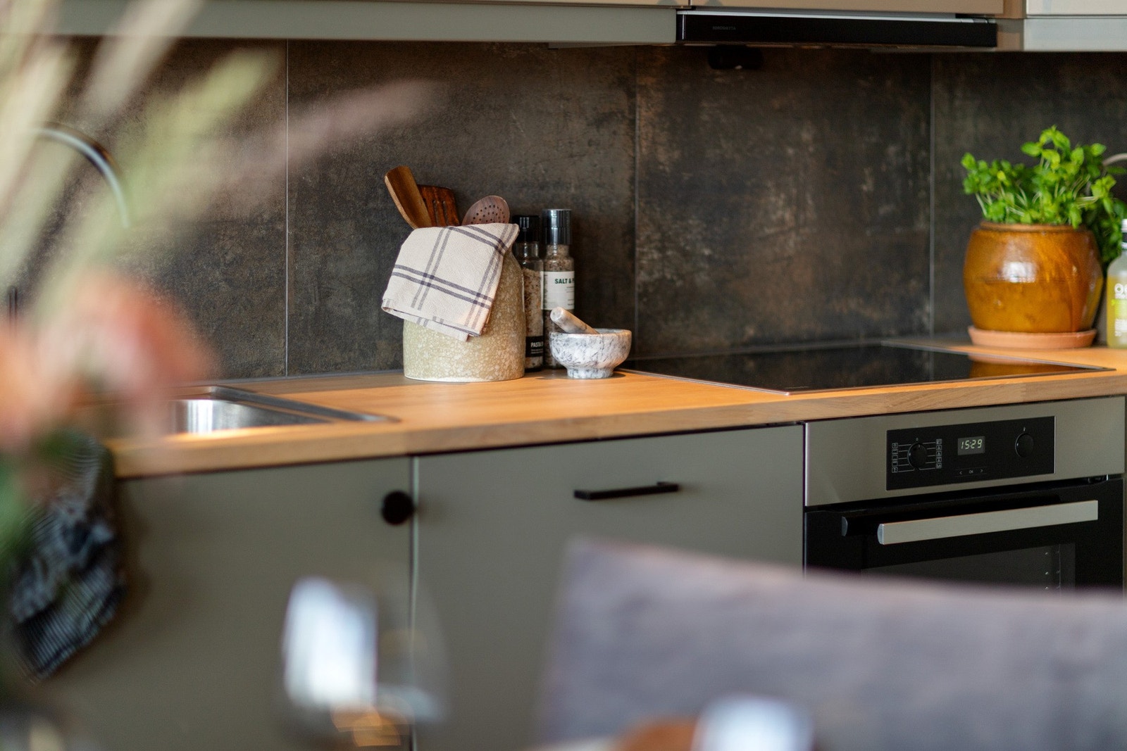 Fliser mellom over- og underskap. Benkeplate av heltre. Integrerte hvitevarer Galleribilde