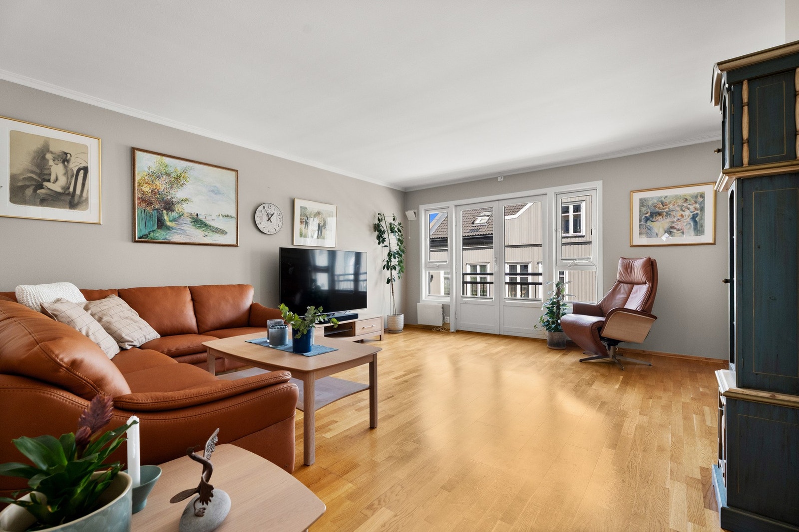 Stuen oppleves som luftig og innbydende, og veggene er malt opp i en lys, delikat beigetone som står godt til det gylne parkettgulvet. Galleribilde