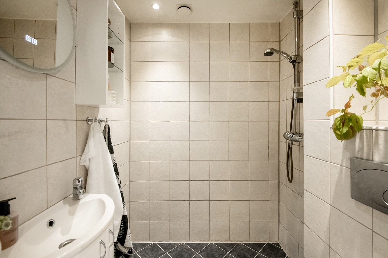 Baderommet har et tidløst uttrykk med flislagte gulv og vegger. Galleribilde