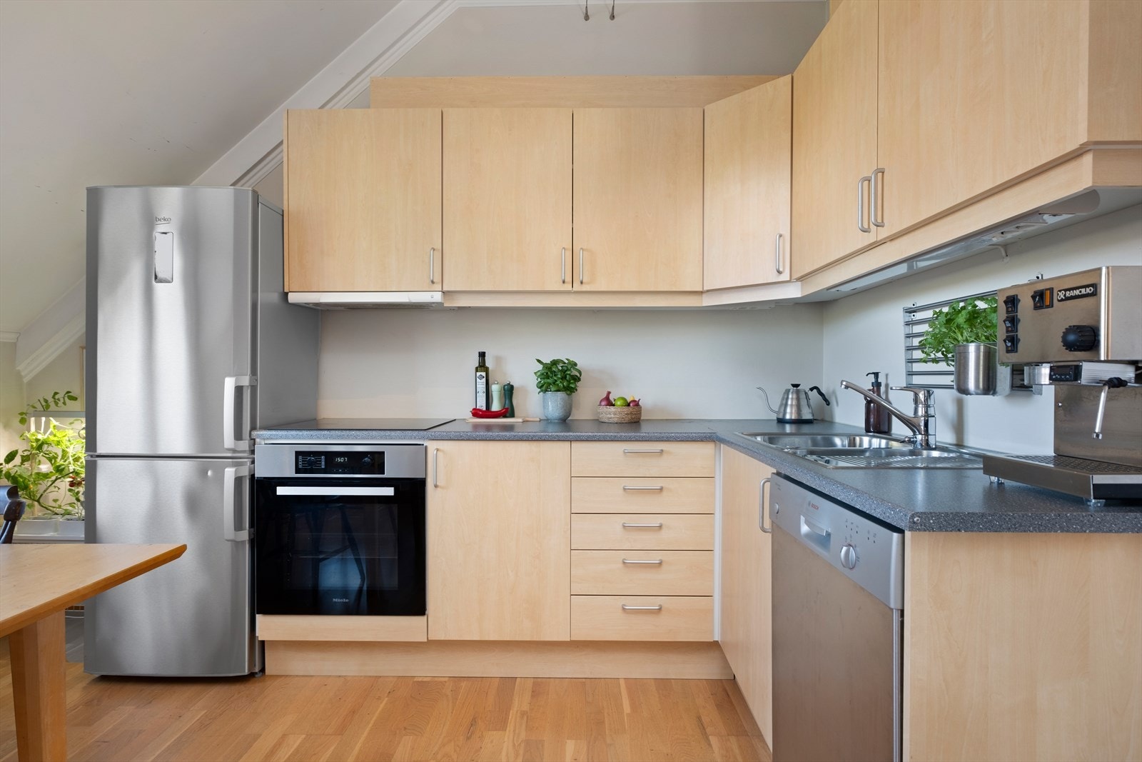 Kjøkkenet er utført i slette fronter og har integrerte hvitevarer som platetopp og stekeovn fra Miele, samt mekanisk avtrekk over stekesone som medfølger leiligheten. Galleribilde