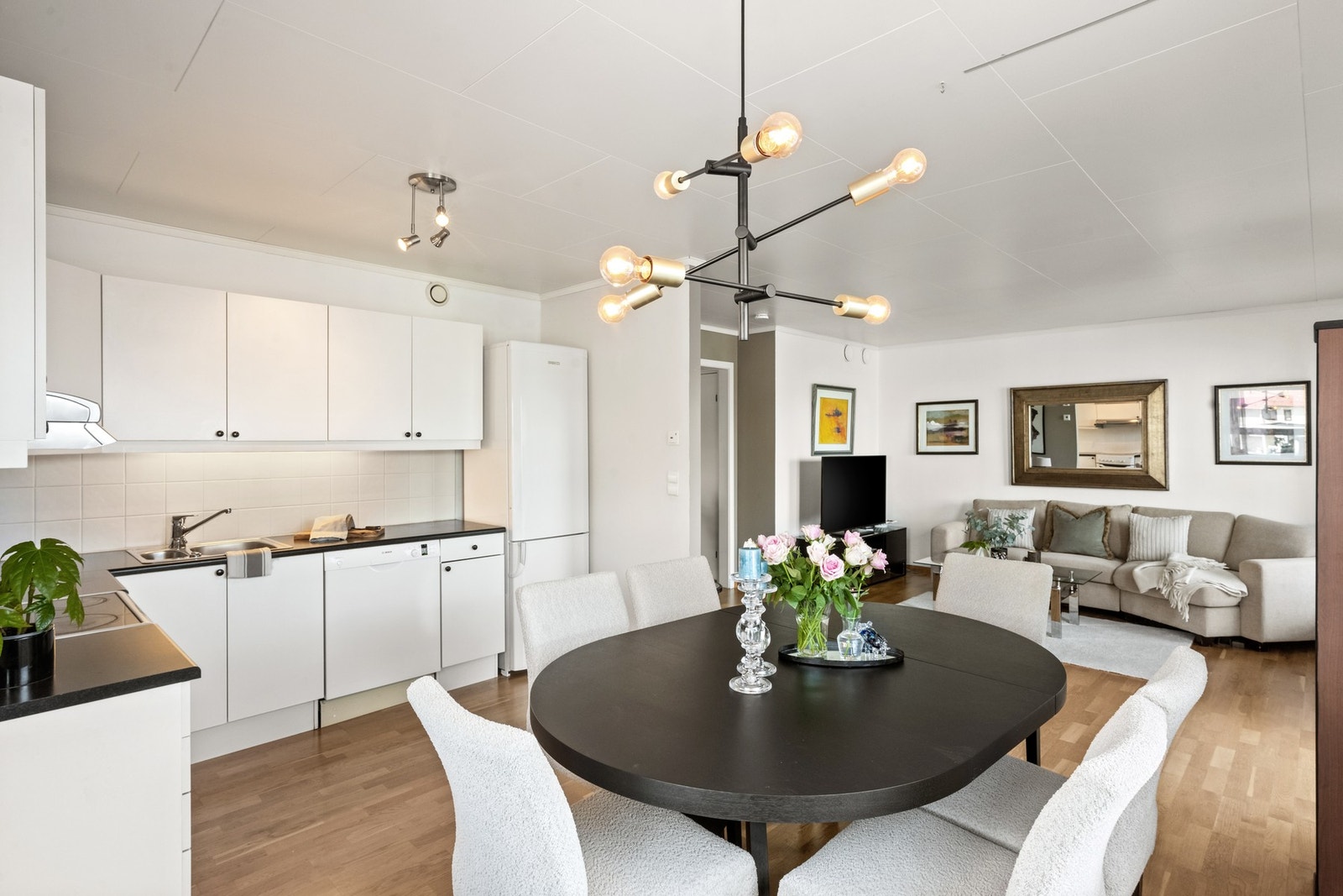 Videre inn i boligen åpner det seg en lys og åpen stue- og kjøkkenløsning, som fungerer som hjemmets naturlige samlingspunkt. Galleribilde