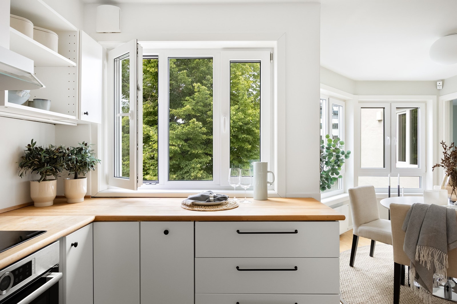 Det er kjøkkeninnredning med glatte fronter og benkeplate av tre. Galleribilde