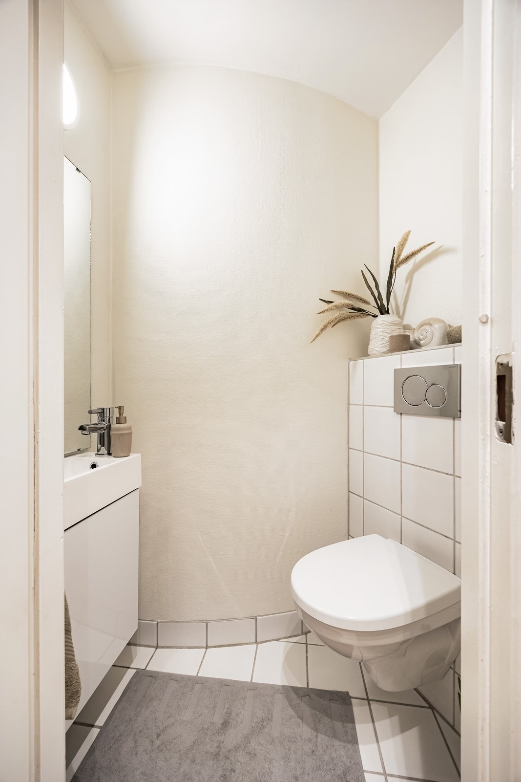 Praktisk separat toalettrom fra 2012 med flislagt gulv og tapetserte og malte vegger. Galleribilde