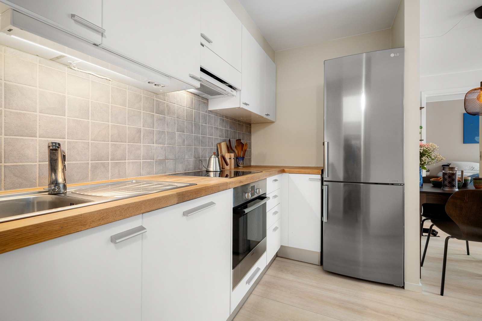 Innredningen har hvite glatte fronter og heltre benkeplate med nedfelt oppvaskkum. Galleribilde