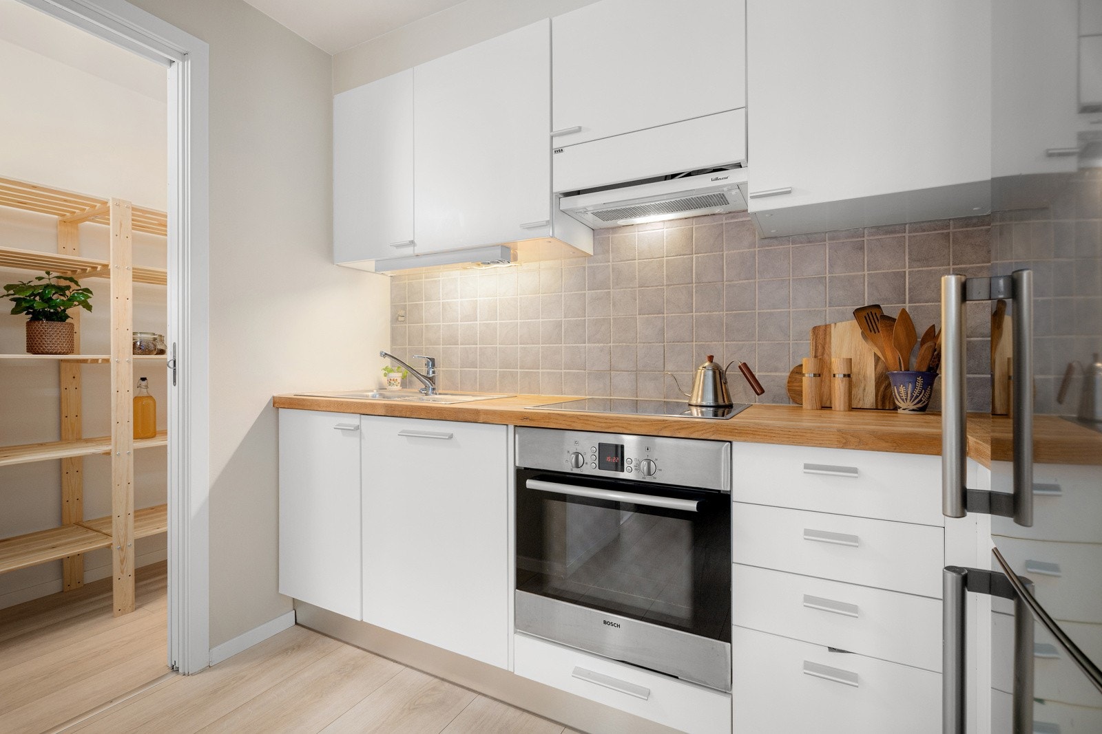 Kjøkkenet er utstyrt med integrerte hvitevarer som nedfelt platetopp, avtrekksvifte, stekeovn og oppvaskmaskin, samt plass til frittstående kjøleskap med frysedel. Galleribilde