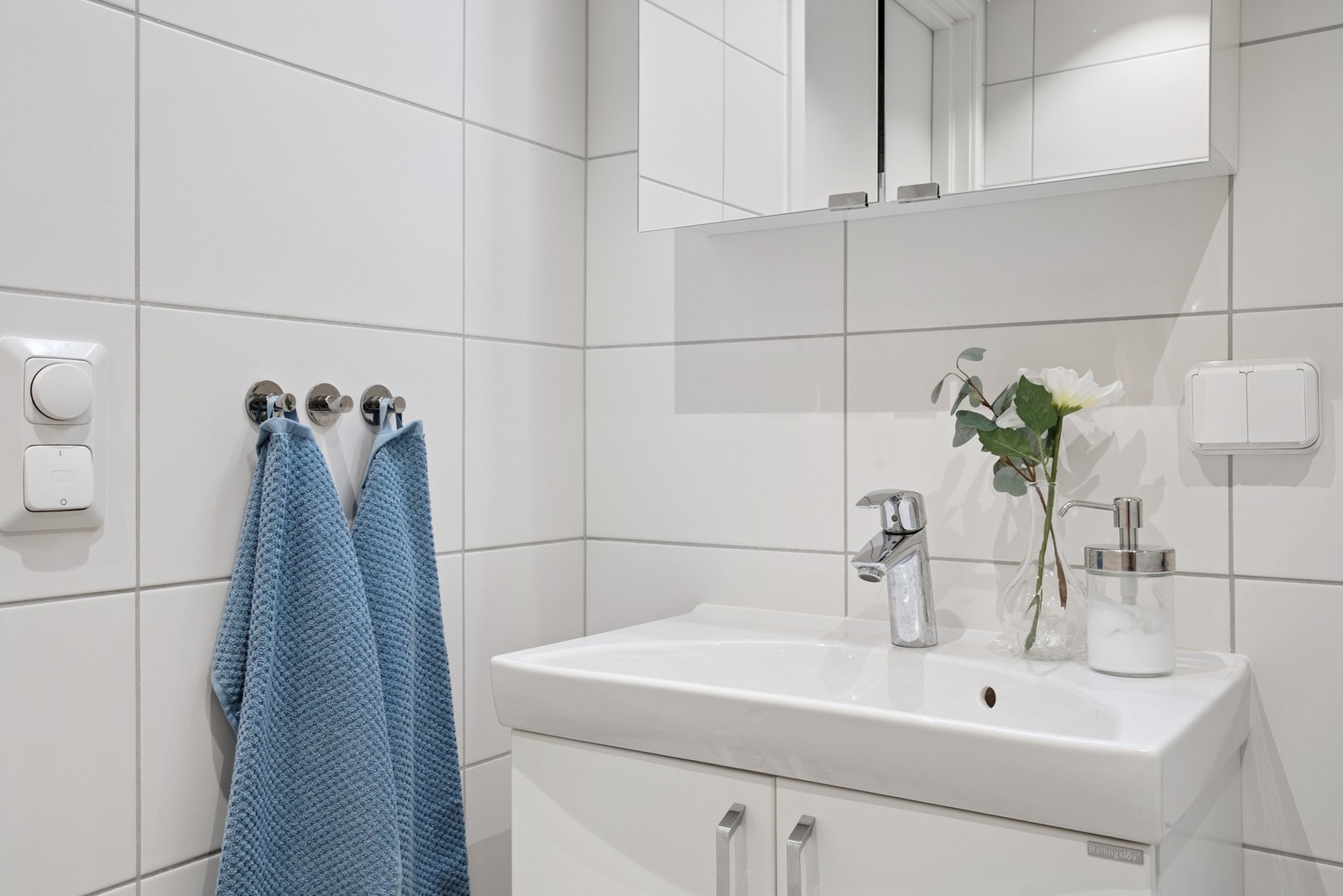 Badet er utstyrt med vegghengt servant, speilskap med overlys og dusjhjørne med innfellbare dører. Galleribilde