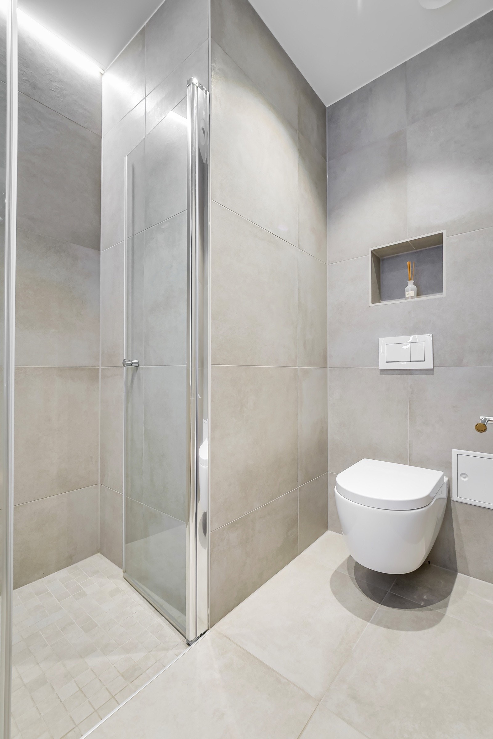 Videre utstyrt med dusjhjørne med regnfalldusj og vegghengt toalett. Galleribilde