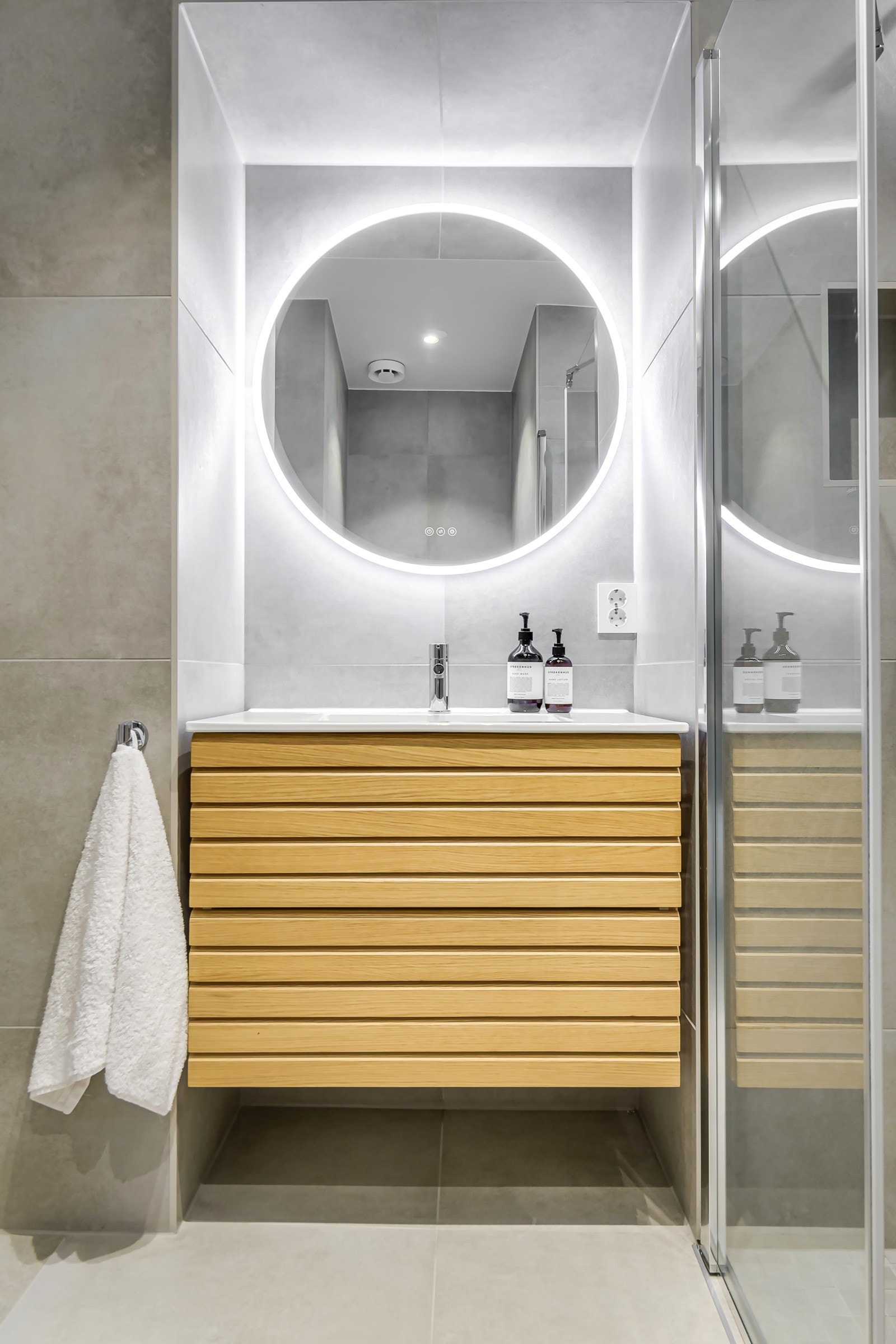 Rommet har en vegghengt servantinnredning med heldekkende servant og ett-greps armatur, speil på vegg med lys og stikkontakt på vegg. Galleribilde