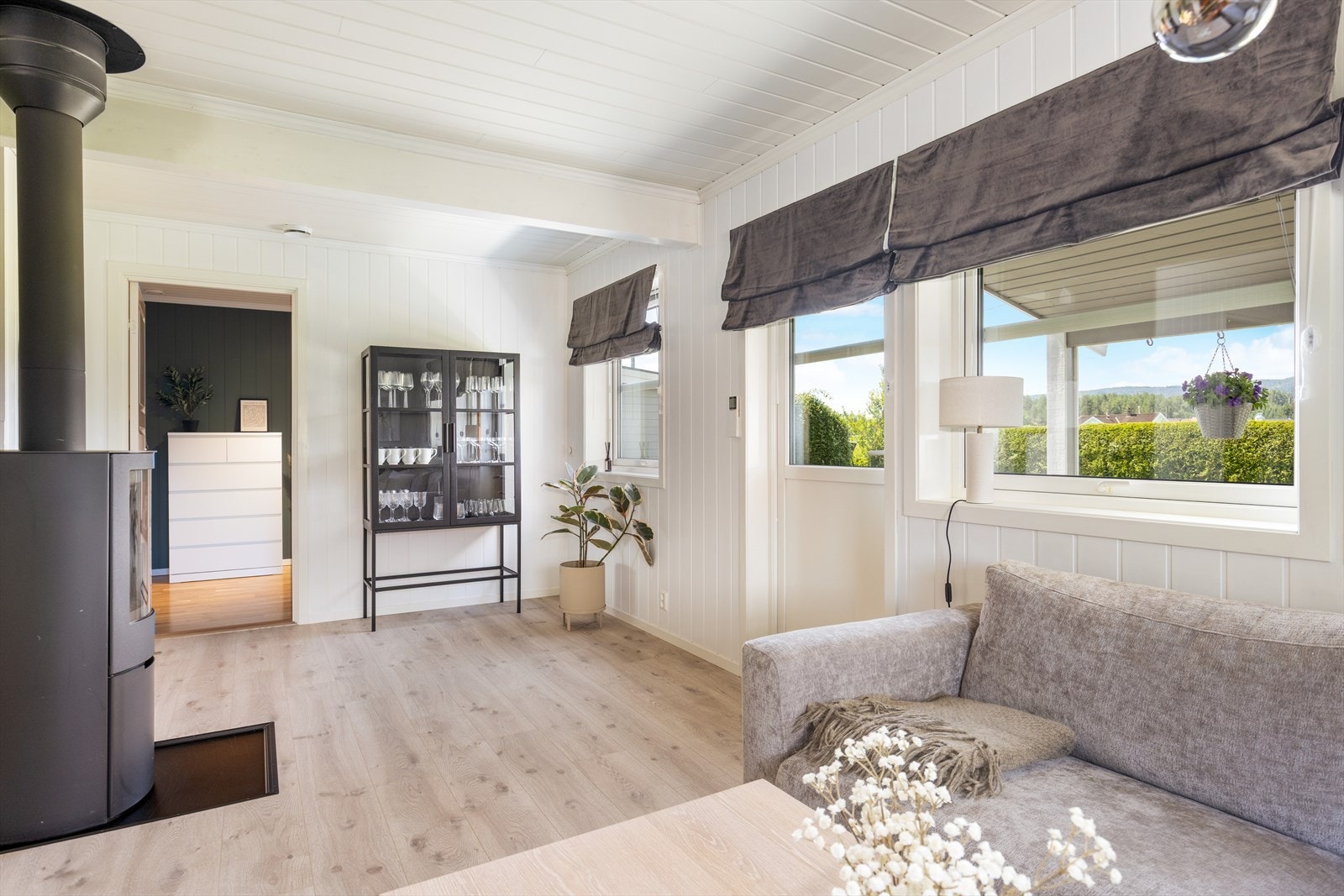 Mot vest i stuen er det store vindusflater som gir fint lysinnslipp til rommet, og det er verandadør ut til terrassen. Galleribilde