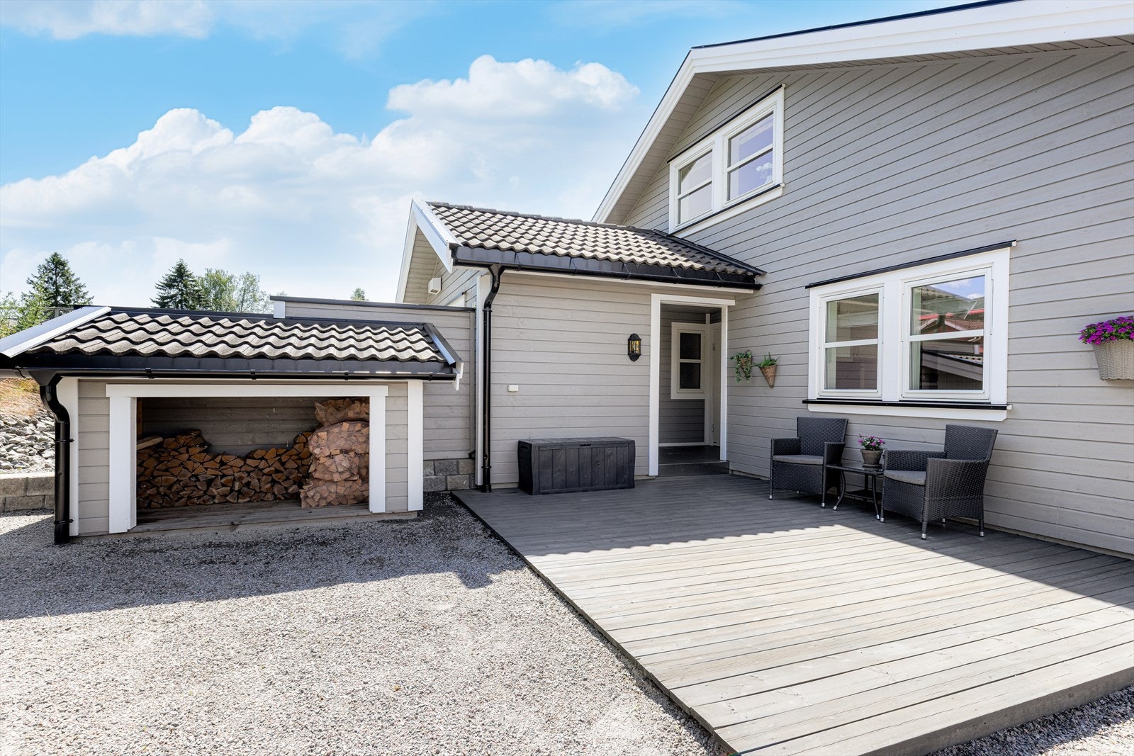 Inngangspartiet til boligen har en nydelig terrasseplatting og inngangen er fint trukket inn i boligen som gir takoverbygg ved døren. Her ligger også tilkomst til den utvendige sportsboden og til teknisk rom/bod. Galleribilde