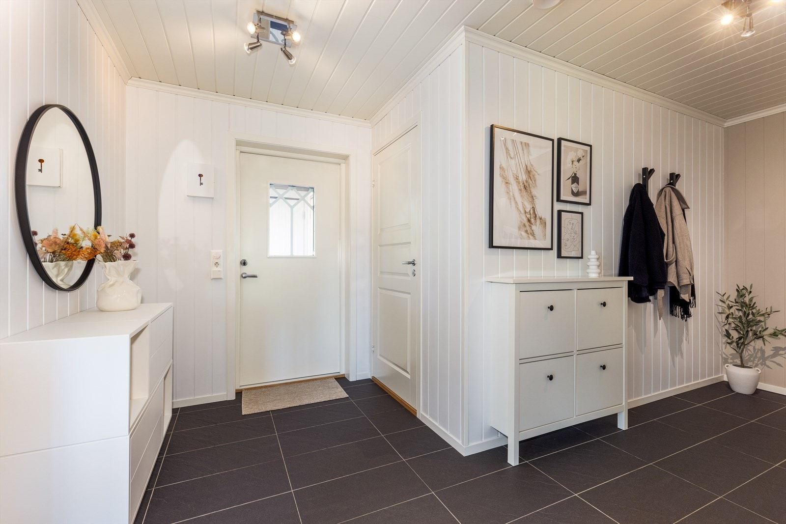 En lys og romslig entré ønsker deg velkommen inn i boligen hvor det er flislagt gulv med varmekabler. Galleribilde