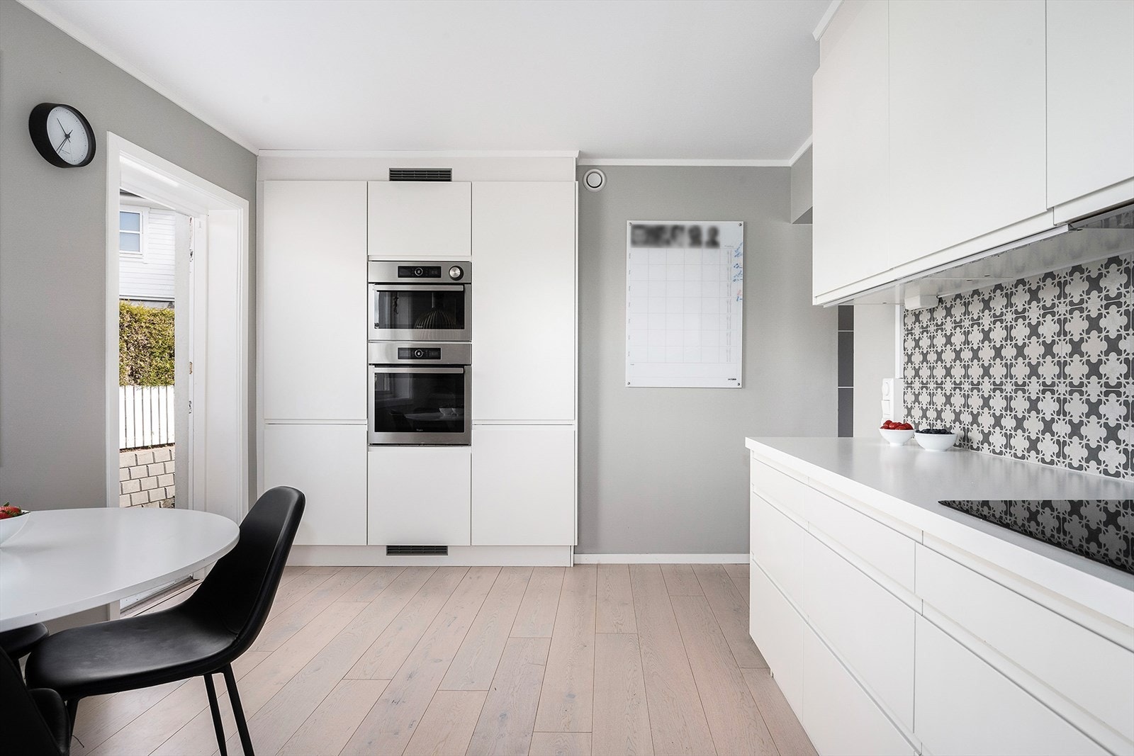 Pent og praktisk kjøkken med hvite glatte fronter og god skap- og benkeplass. Galleribilde