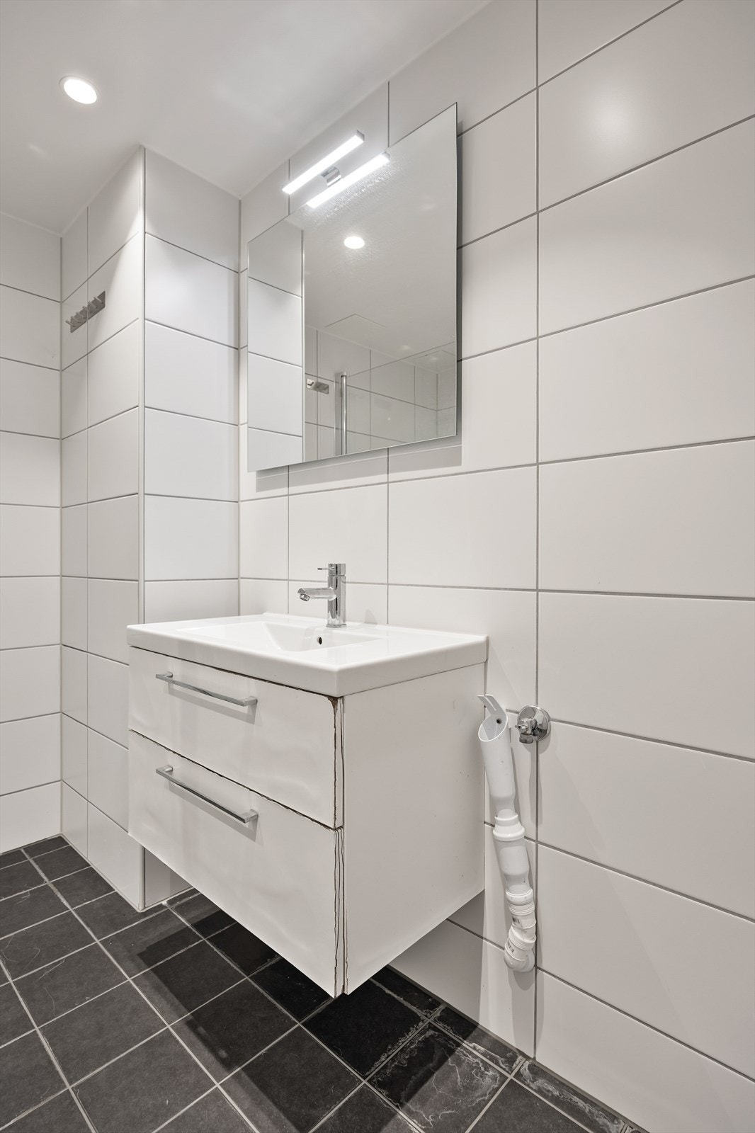 Badet har moderne innredning og speil med belysning for en behagelig start på dagen. Galleribilde