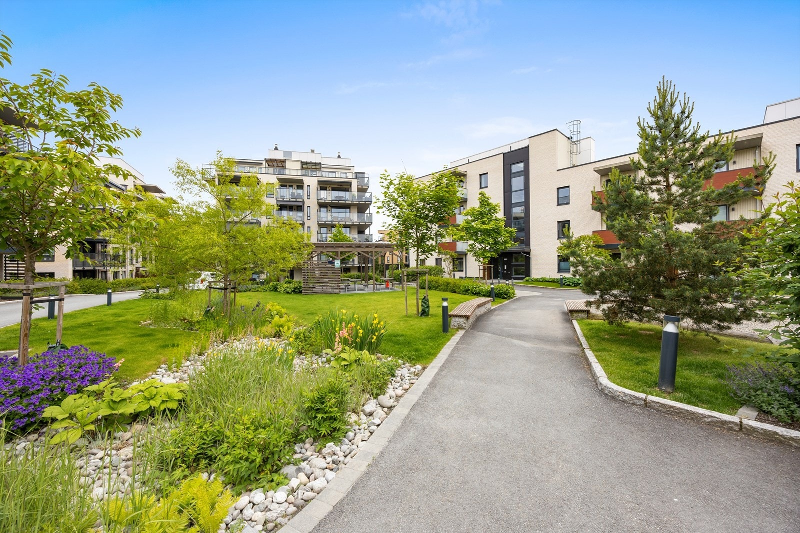 Innbydende felles hageanlegg med vakker beplantning og hyggelige sittegrupper. Galleribilde