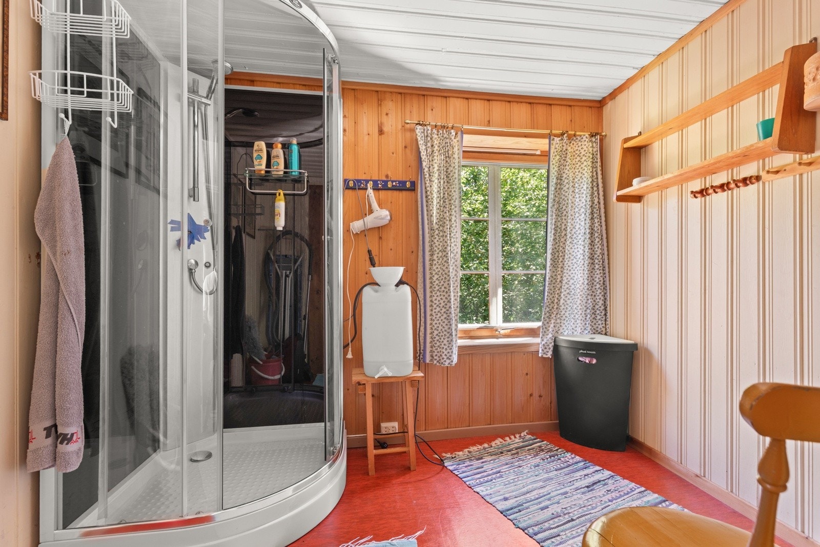 Hytta har et baderom med dusjkabinett og god plass til morgenstellet. Vannet til dusjen fylles manuelt i en beholder ved siden av dusjen - en praktisk løsning på ei hytte uten innlagt vann. Galleribilde