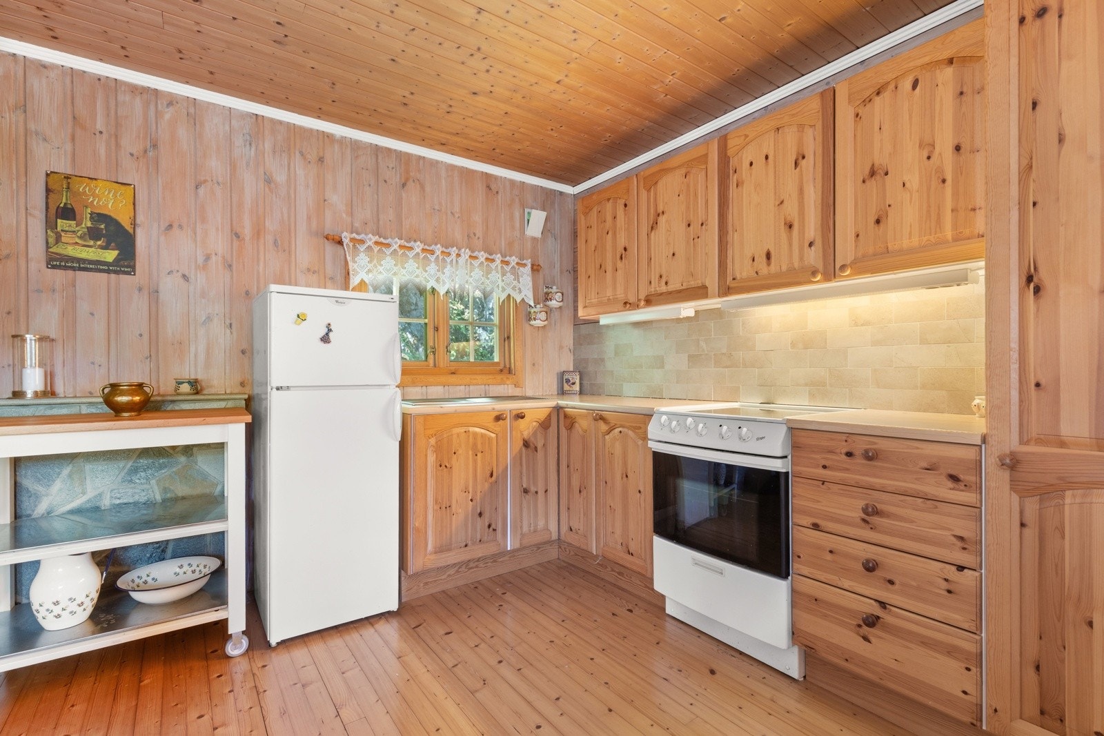 Kjøkkenet har innredning med profilerte fronter og benkeplaten av laminat. Kjøkkenet har nedsenket vask, kjøleskap og stekeovn. Galleribilde