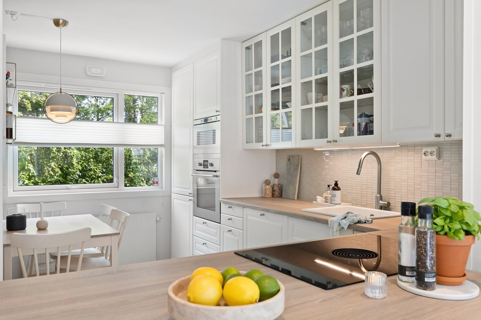 Kjøkken med profilerte hvite fronter, laminat benkeplate med nedfelt stålkum med ett basseng, ettgreps kjøkkenkran med uttrekk Galleribilde