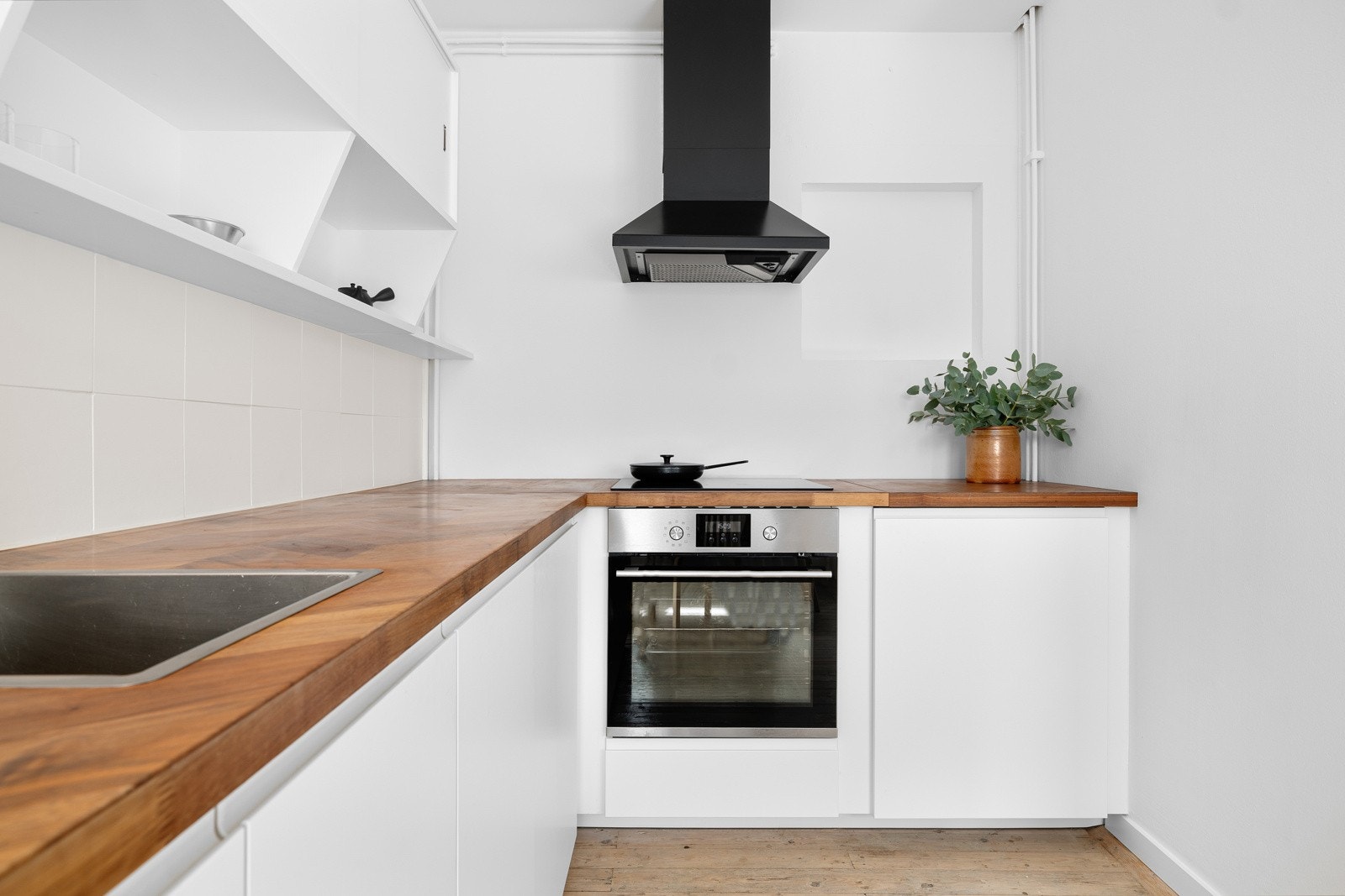 Tidløs og pen kjøkkeninnredning fra 2016. Innredningen har lyse, glatte fronter med laminat benkeplate (eksklusiv valnøtt i fiskebensmønster). Galleribilde