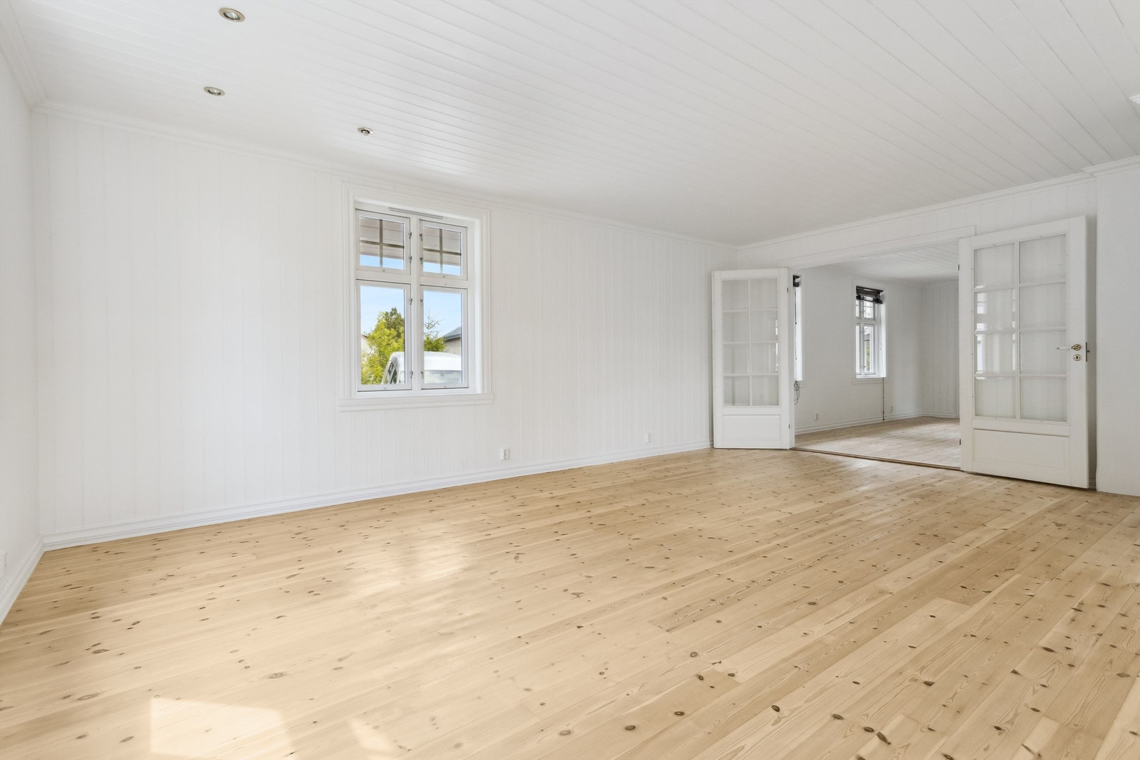 Stue med tregulv og tofløyet dør Galleribilde