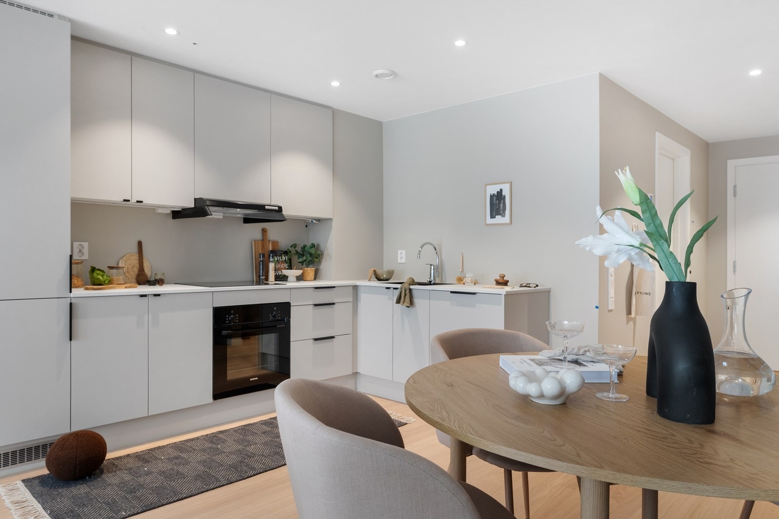 Flott kjøkken med integrerte hvitevarer, glatte hvite fronter og godt med både skap- og benkeplass Galleribilde