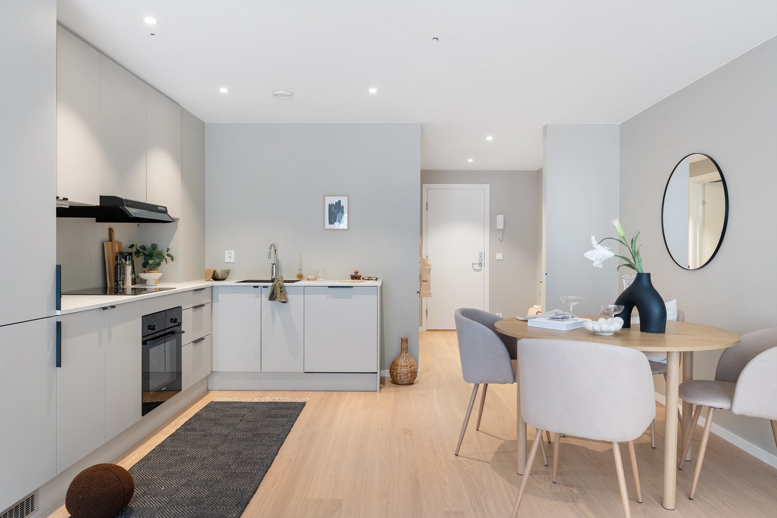 Den åpne kjøkkenløsningen skaper en sosial atmosfære med nærhet til både spisebord og stue Galleribilde