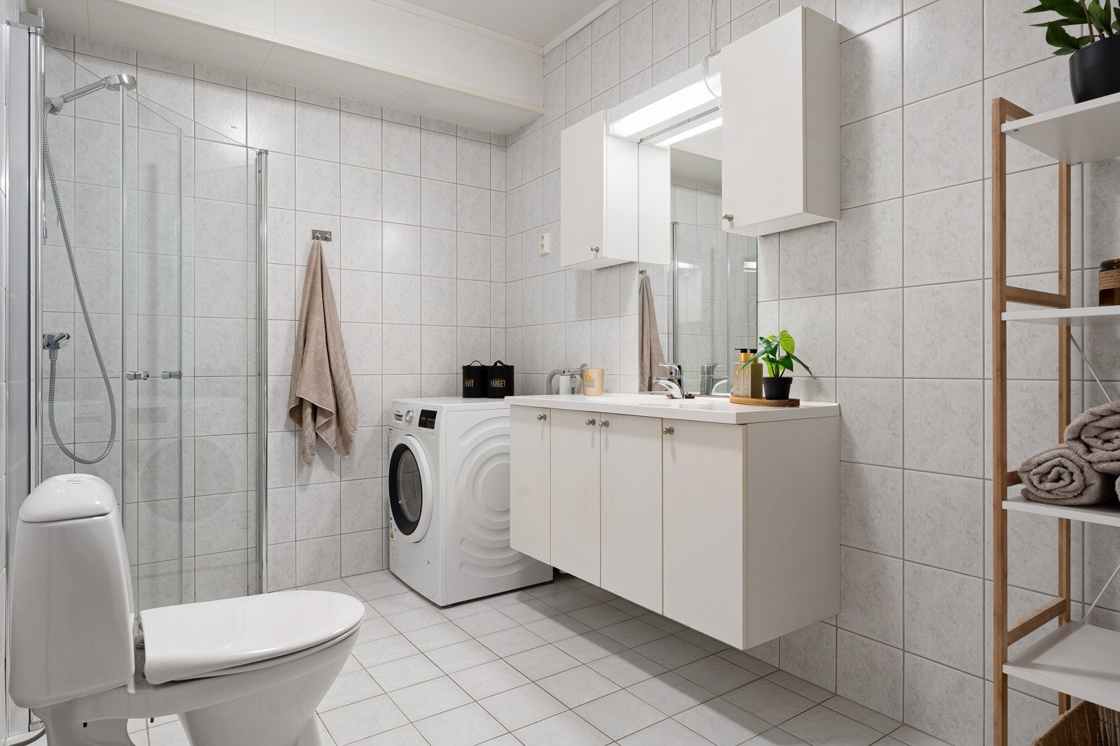 Flislagt og stort bad med god plass til vaskemaskin og tørketrommel. Nye dusjdører, blandebatteri og dusjsett montert i 2025. Galleribilde