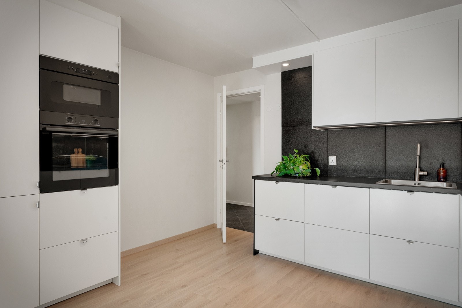 Både induksjonstopp, stekeovn, mikrobølgeovn, kjøleskap med frysedel og oppvaskmaskin er integrert i innredningen Galleribilde