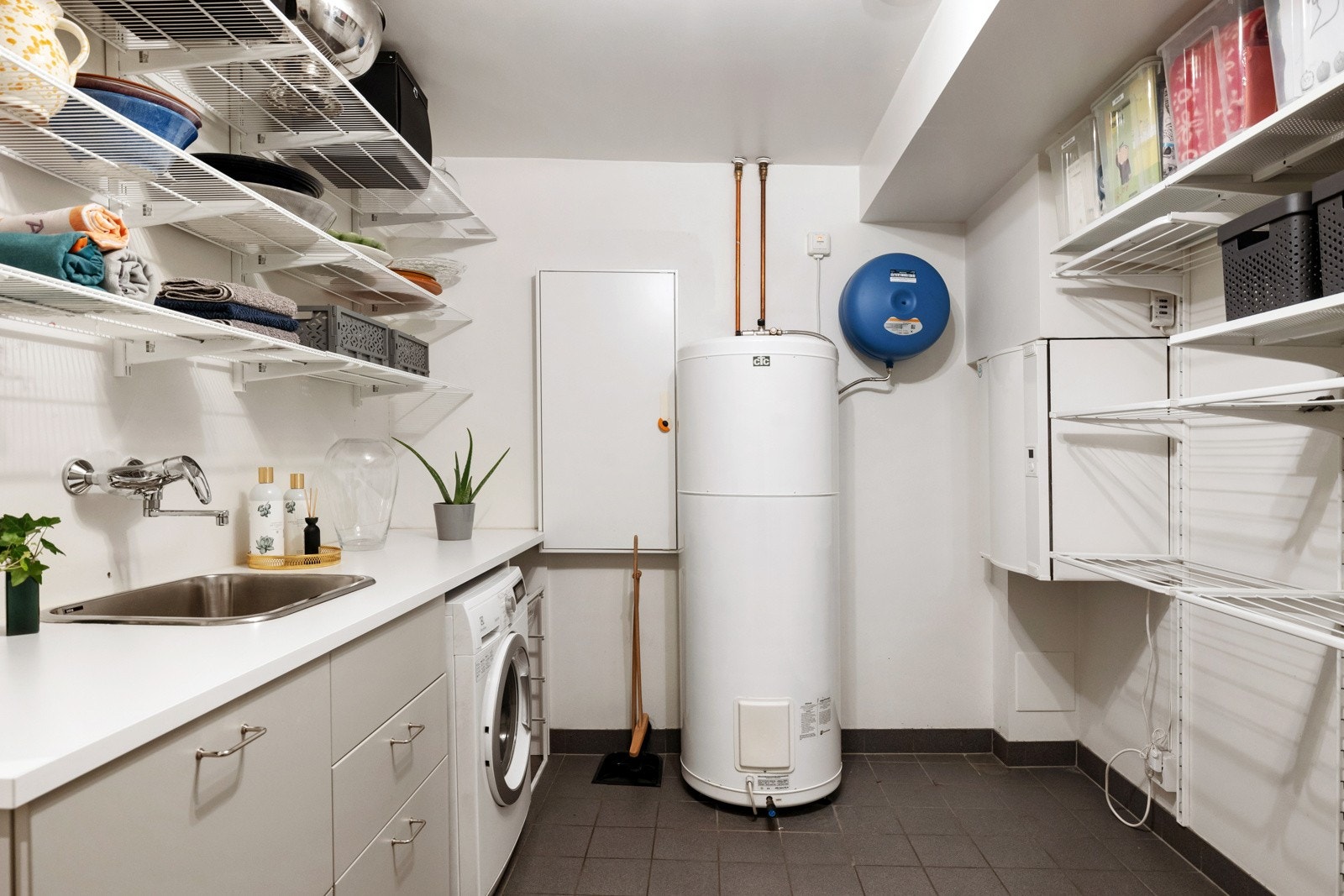 Opplegg for vaskemaskin. Her er også varmtvannsbereder, ventilasjonsenhet og sikringsskap plassert. Galleribilde