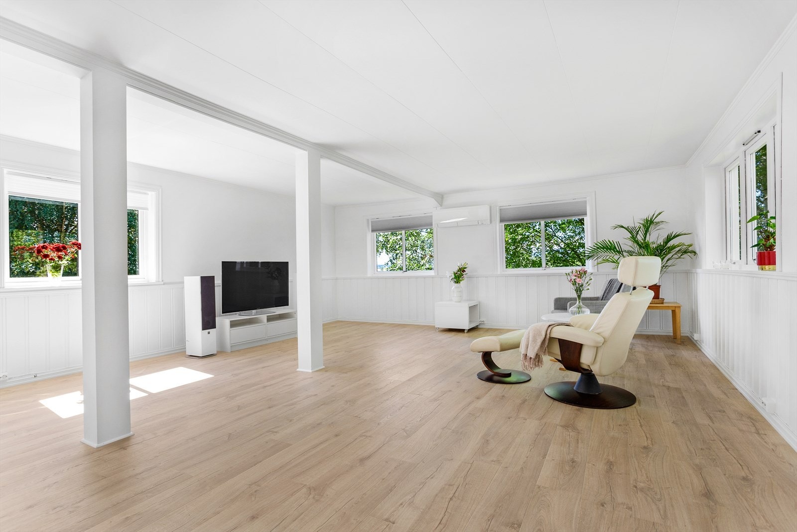 Lys og romslig stue med delvis åpen kjøkkenløsning. Galleribilde