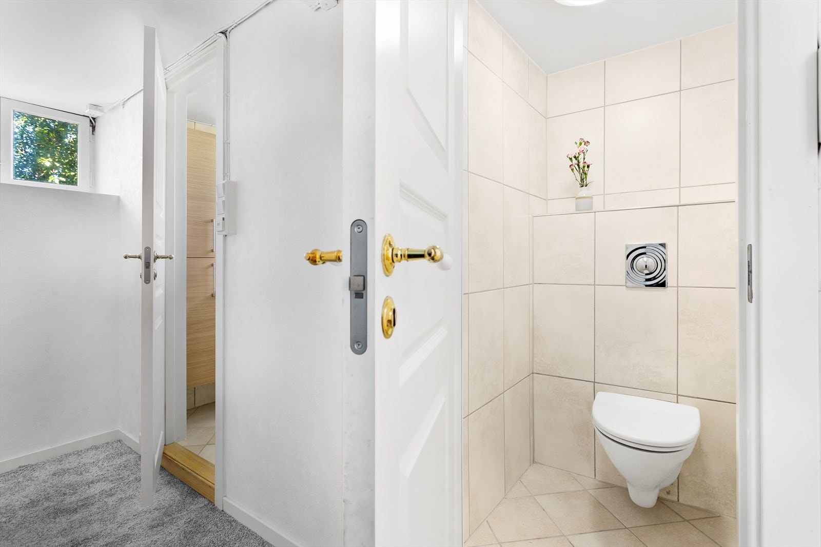 Kjelleren har separat bad og toalett. Flislagt toalett med vegghengt toalettskål Galleribilde