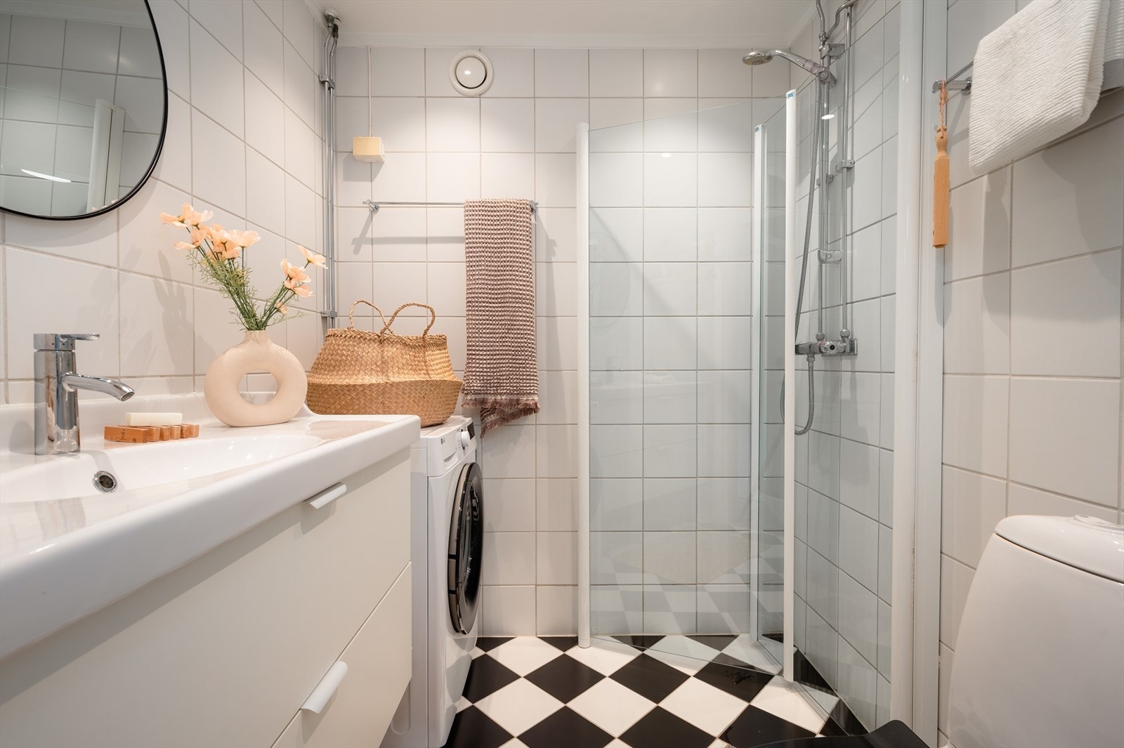 Flislagt bad med dusjvegger, moderne servant og opplegg for vaskemaskin. Galleribilde