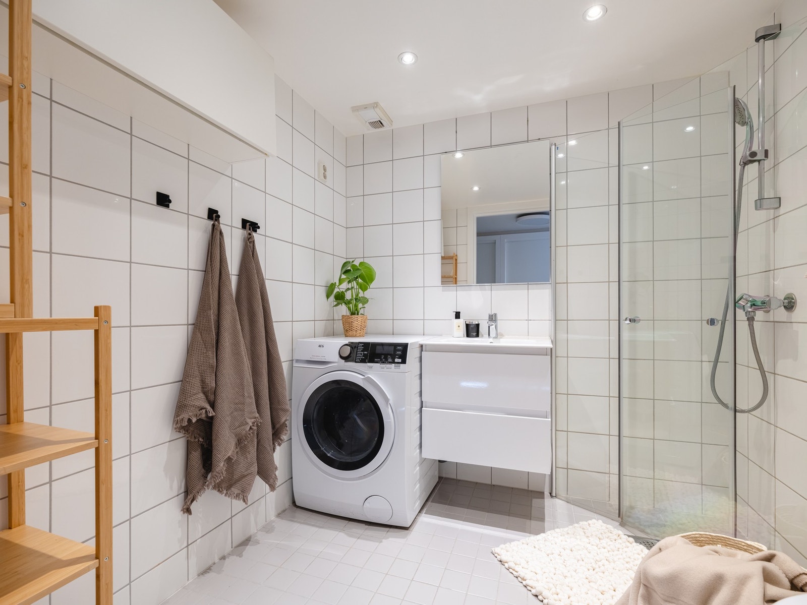 Badet er utstyrt med vegghengt servantinnredning med skuffer, ovenpåliggende servant med ett-greps armatur og vegghengt baderomsmøbel med dør. Galleribilde