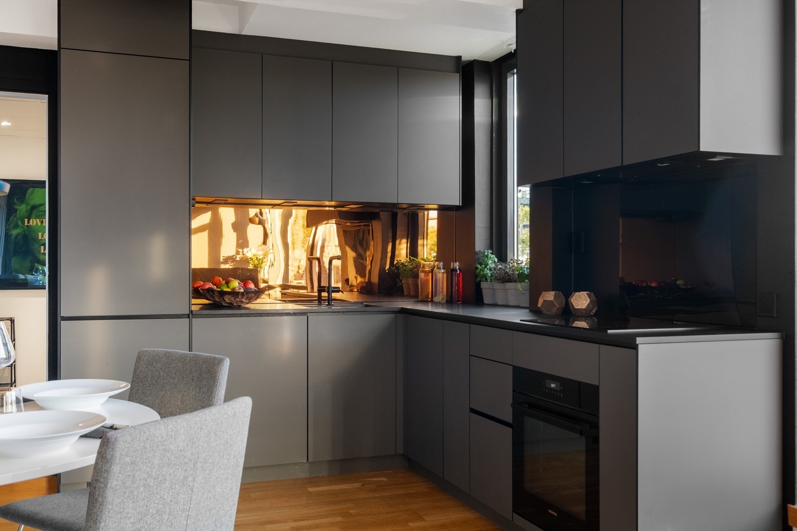 Moderne kjøkkeninnredning med glatte fronter, laminat benkeplate med nedfelt vaskekum. belysning over benkeplaten og overskap. Galleribilde