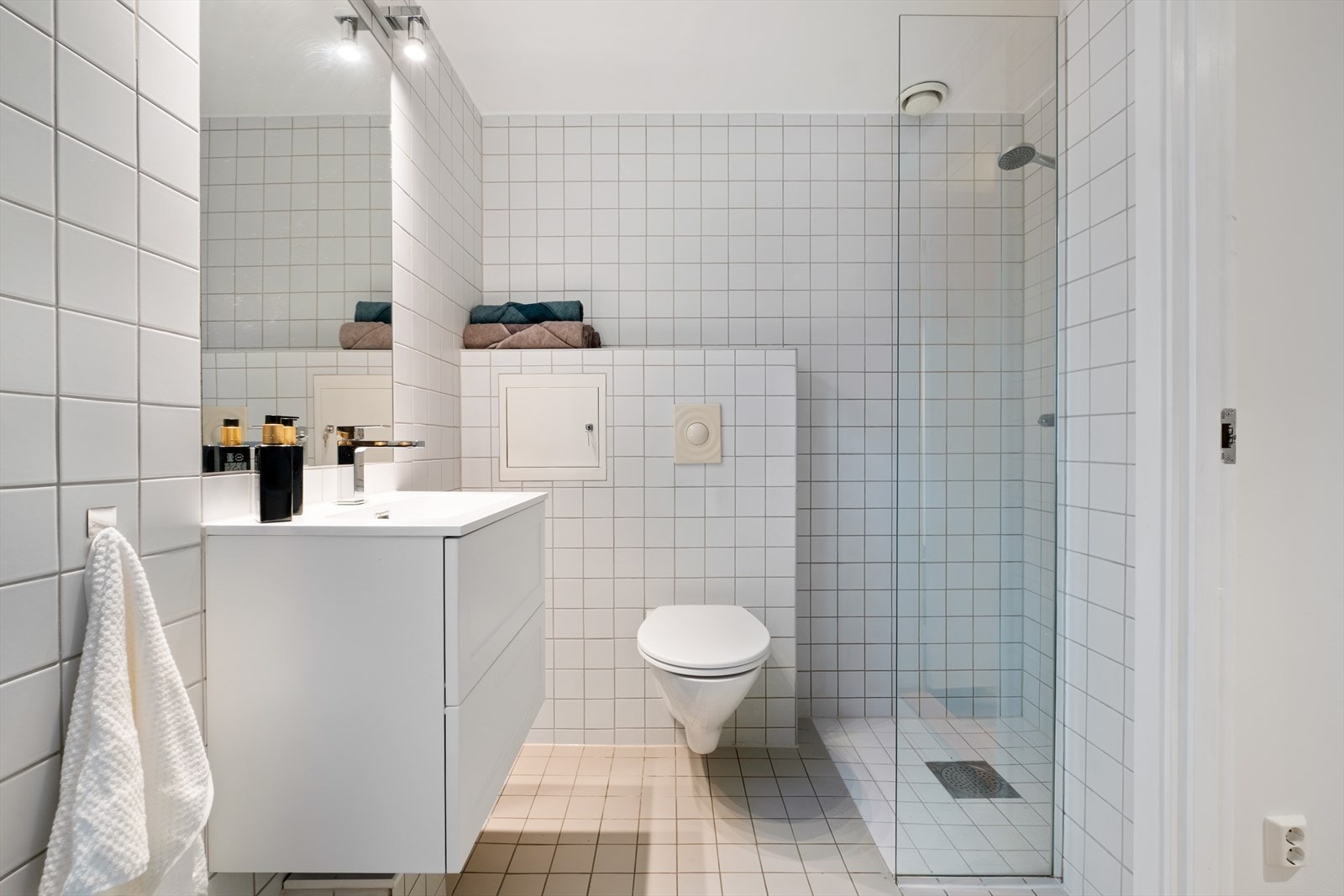 Flislagt baderom fra 2007 med varme i gulvet. I 2025 ble det lagt nye fliser i dusjsonen, ny silikon, ny servant og servantskap, samt nytt baderomslys. Galleribilde