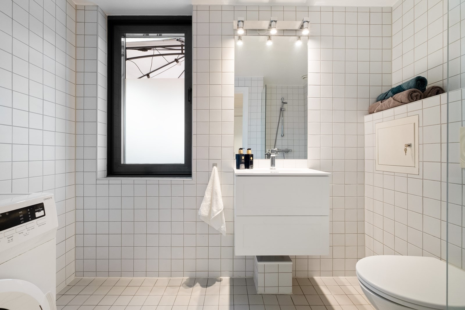 Baderommet er innredet med vegghengt klosett, servant på innredning og dusjhjørne med faste vegger. Galleribilde