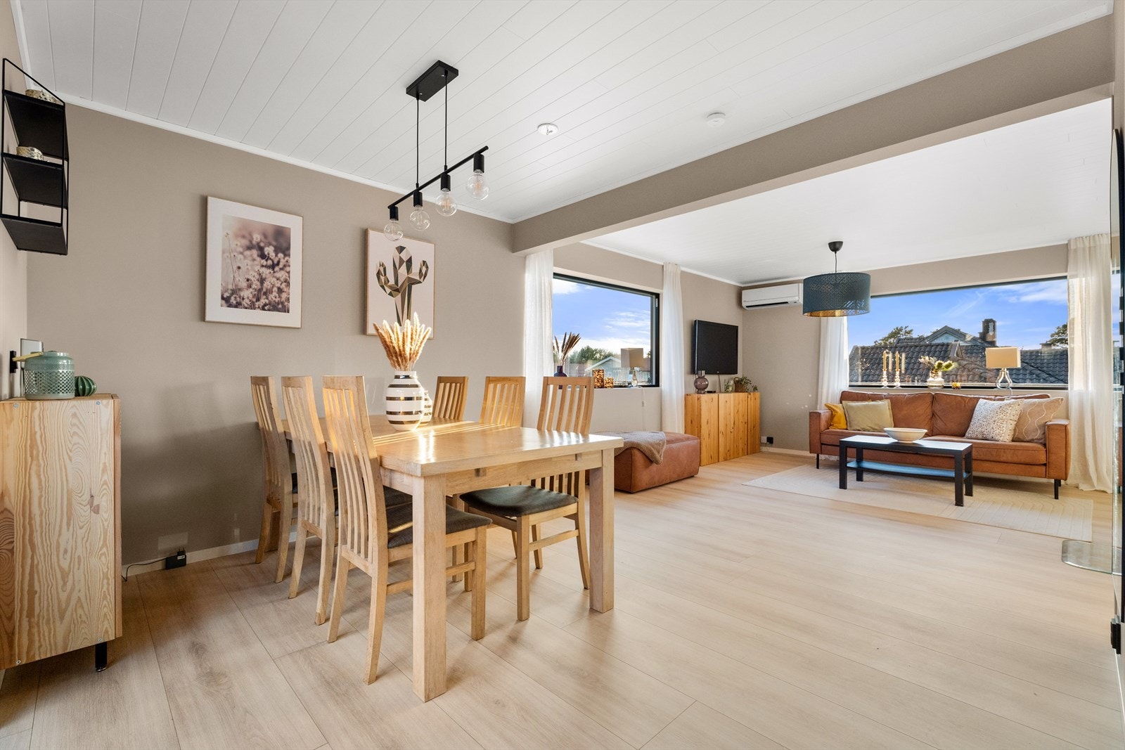 Store vindusflater i stuen slipper inn rikelig med dagslys og forsterker den åpne og lyse romfølelsen Galleribilde