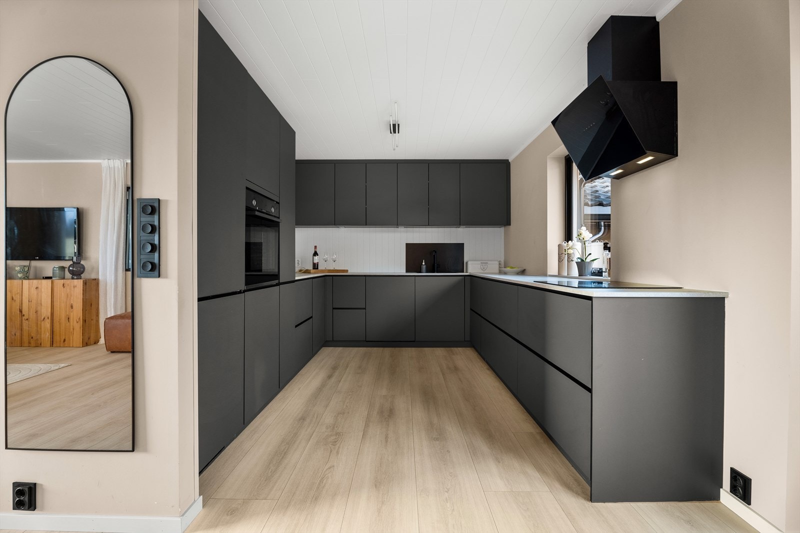 Kjøkkeninnredning er fra Kvik med moderne, grå slette fronter og benkeplate i laminat Galleribilde