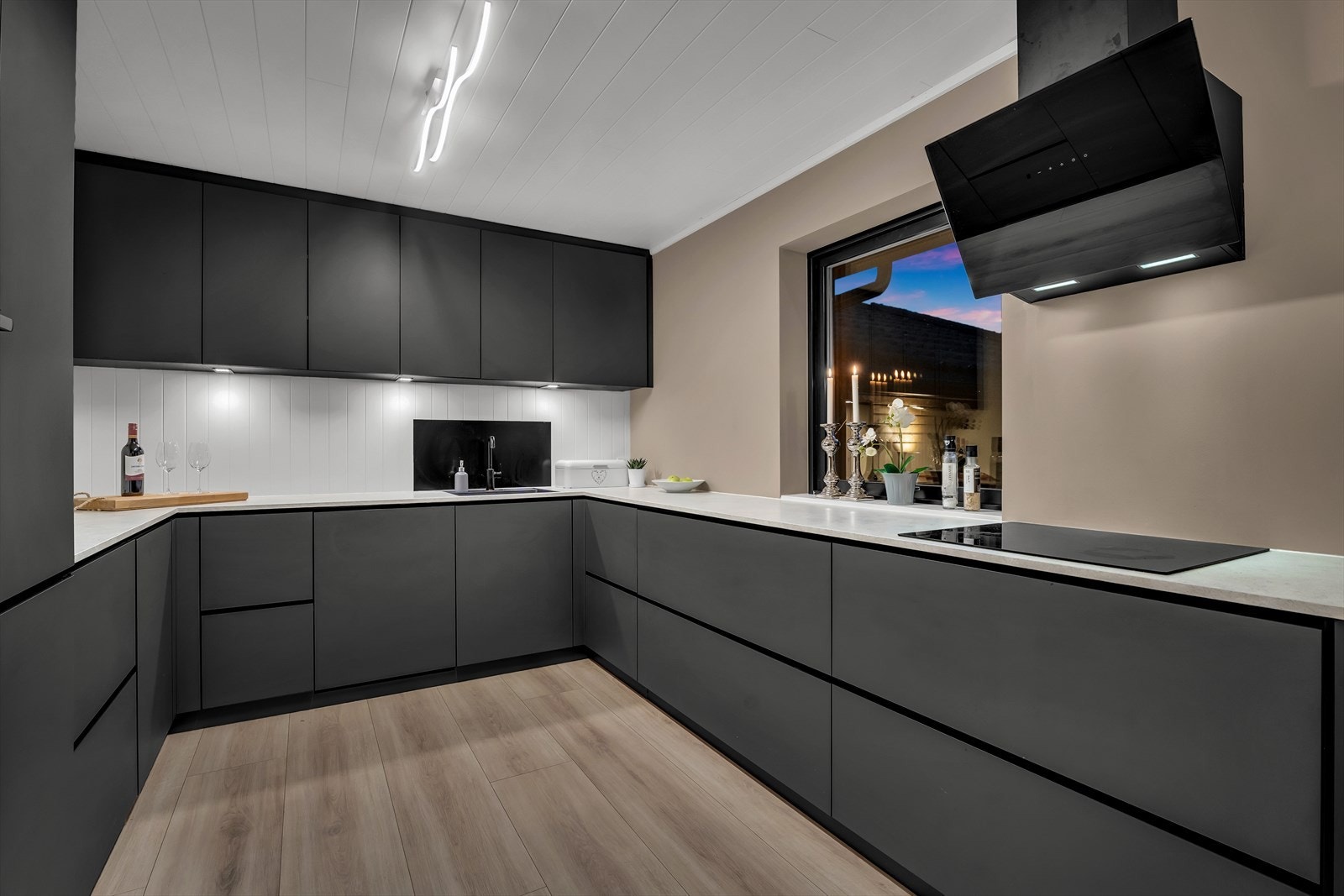 Kjøkkenet er utstyrt med integrerte hvitevarer som induksjonstopp, komfyr, oppvaskmaskin og kjøl/fryseskap Galleribilde