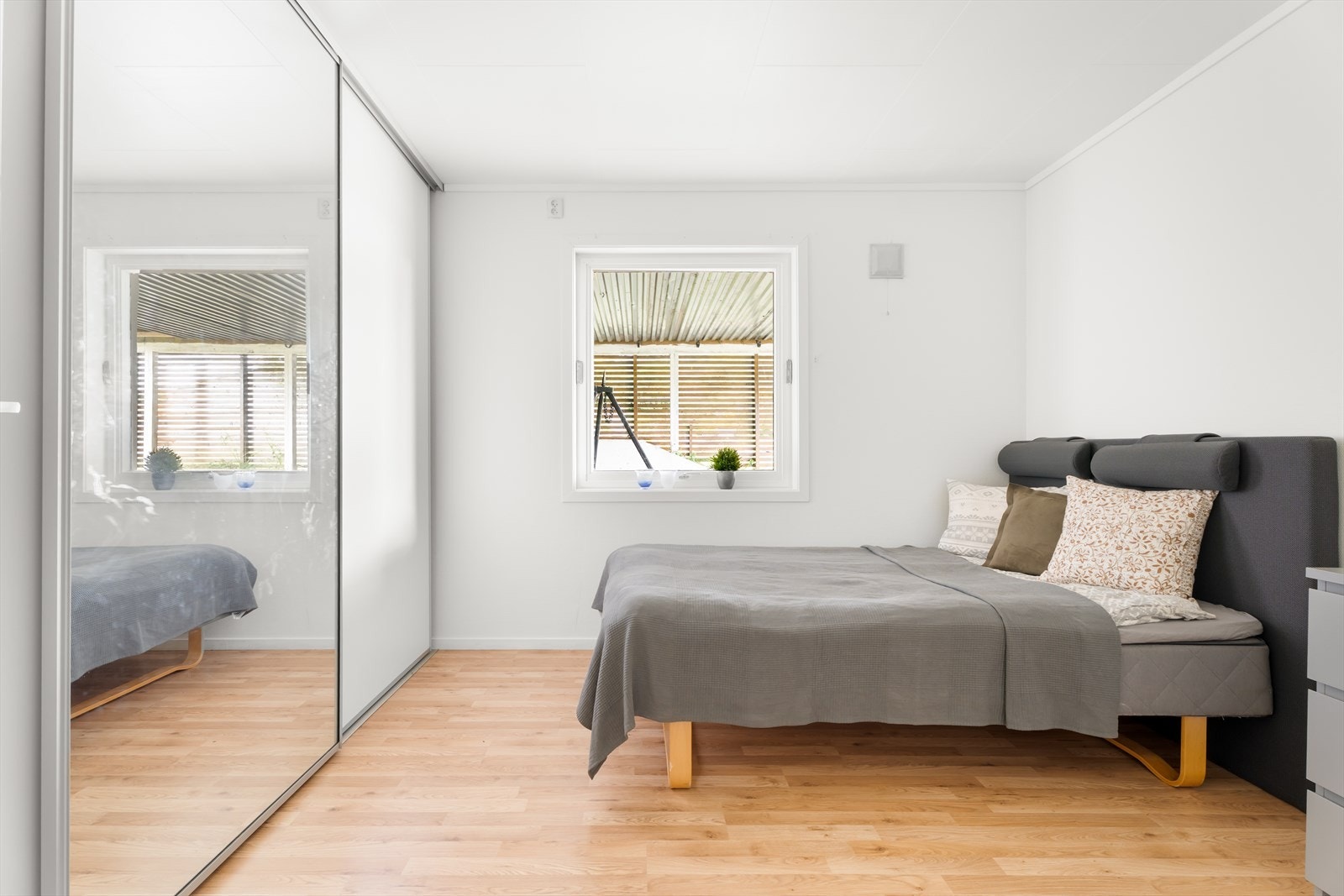 I kjelleren har man boligens tredje soverom. Soverommet er romslig med plass til dobbeltseng og en praktisk garderobeløsning med speil som gir både oppbevaringsplass og en følelse av ekstra rom Galleribilde