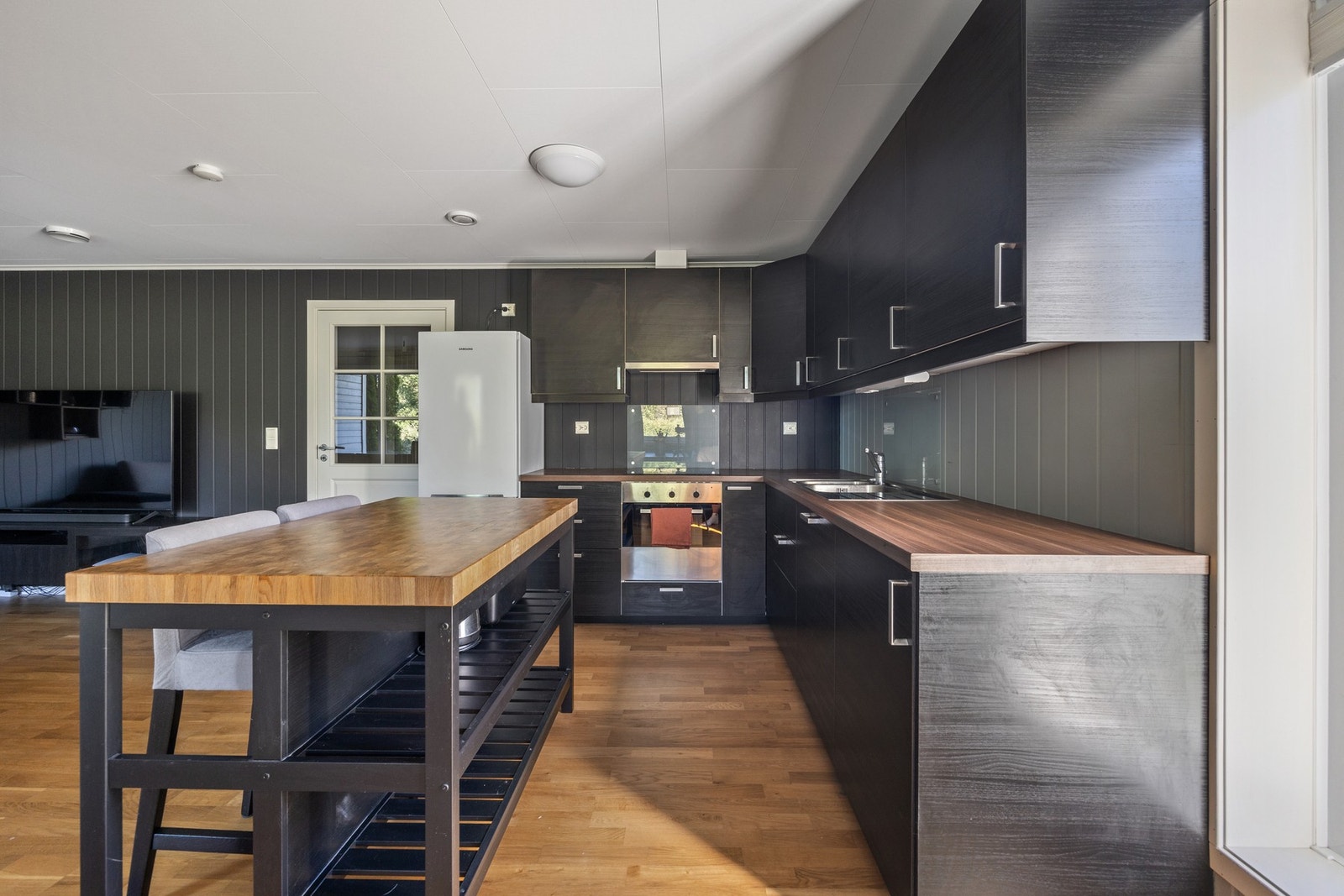 Moderne kjøkken med integrert platetopp, stekeovn og oppvaskmaskin, samt avsatt plass for kjøleskap. Galleribilde