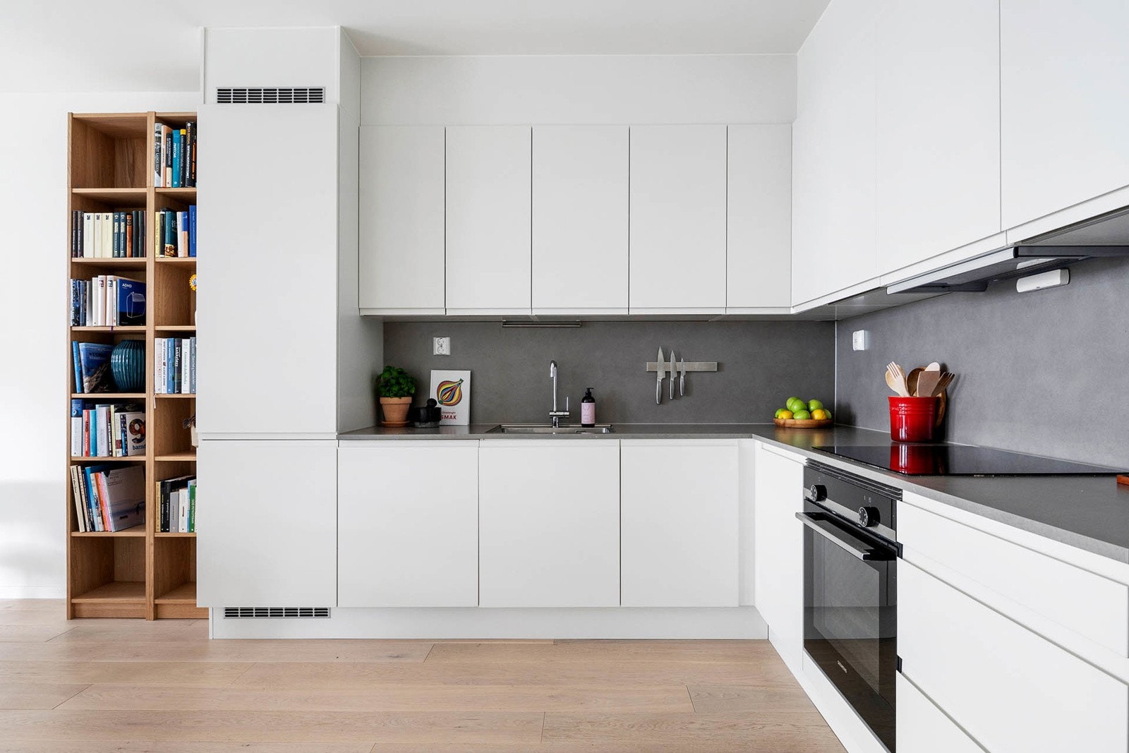 Kjøkkeninnredning med integrert kjøl/fryseskap, komfyr, koketopp og oppvaskmaskin Galleribilde